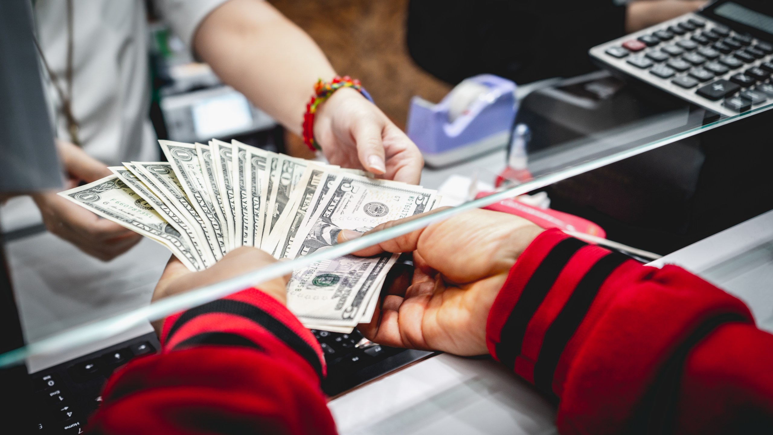 Cash is exchanged in a file photo. (Credit: Getty Images)