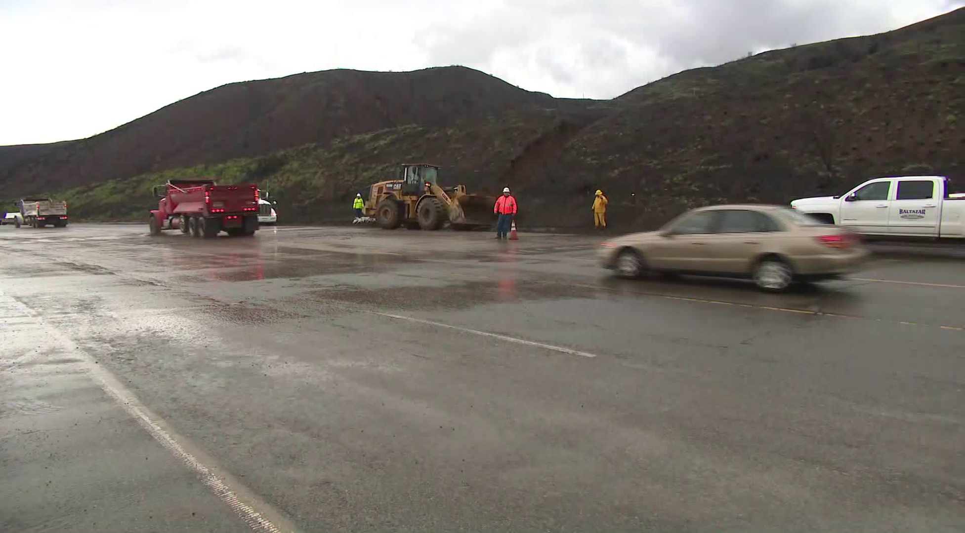 Caltrans crews work to cleanup debris along Pacific Coast Highway during a winter storm on Jan. 14, 2019. (Credit: KTLA)