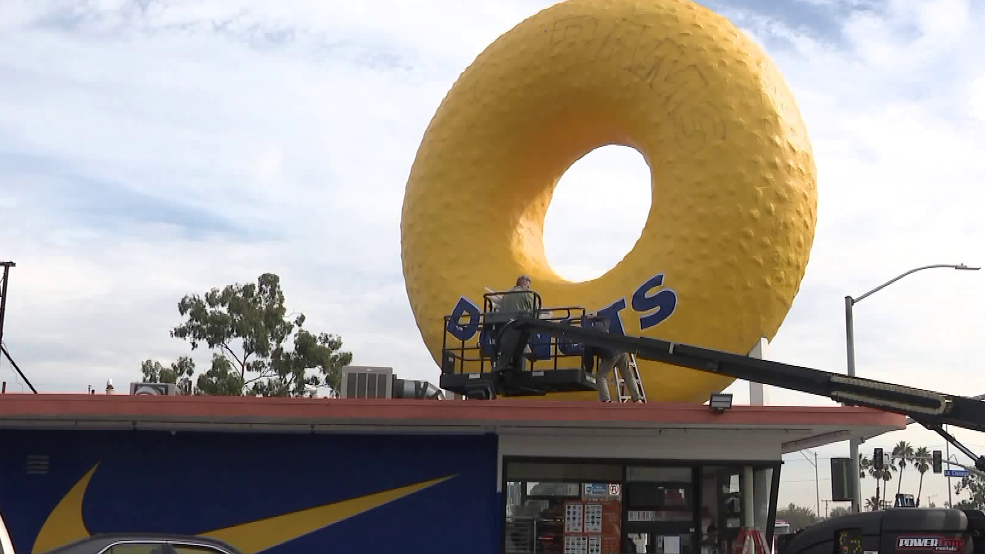 The iconic sign at Randy's Donuts in Inglewood was being transformed on Jan. 28, 2019, as a tribute to the L.A. Rams playing in Super Bowl 53. (Credit: KTLA)