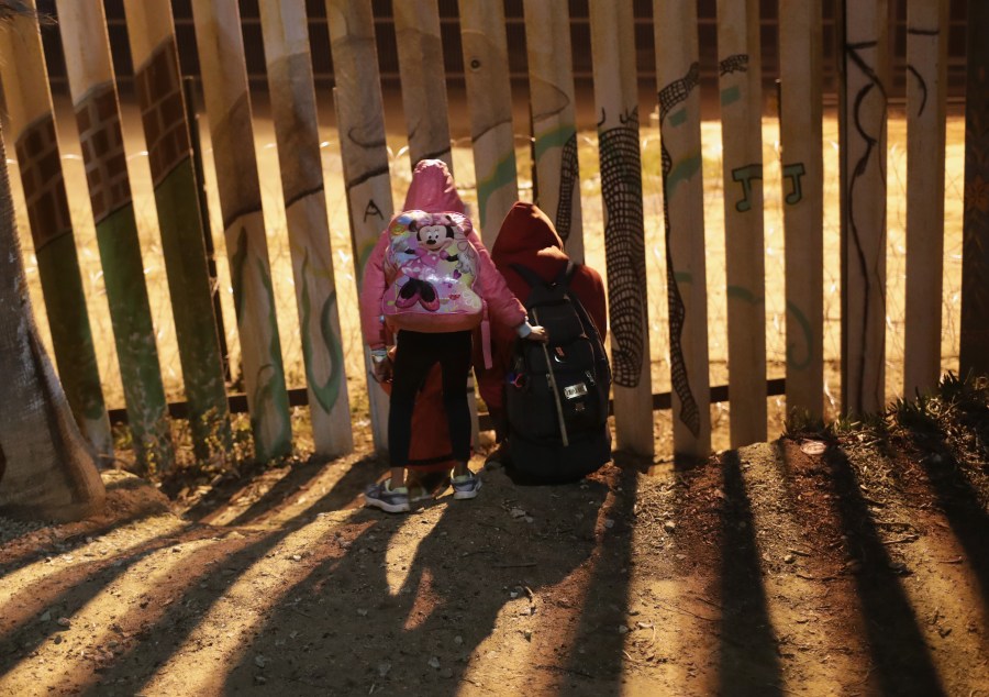 Migrants look across the U.S.-Mexico border fence on Dec. 2, 2018 from Tijuana, Mexico. (Credit: John Moore/Getty Images)