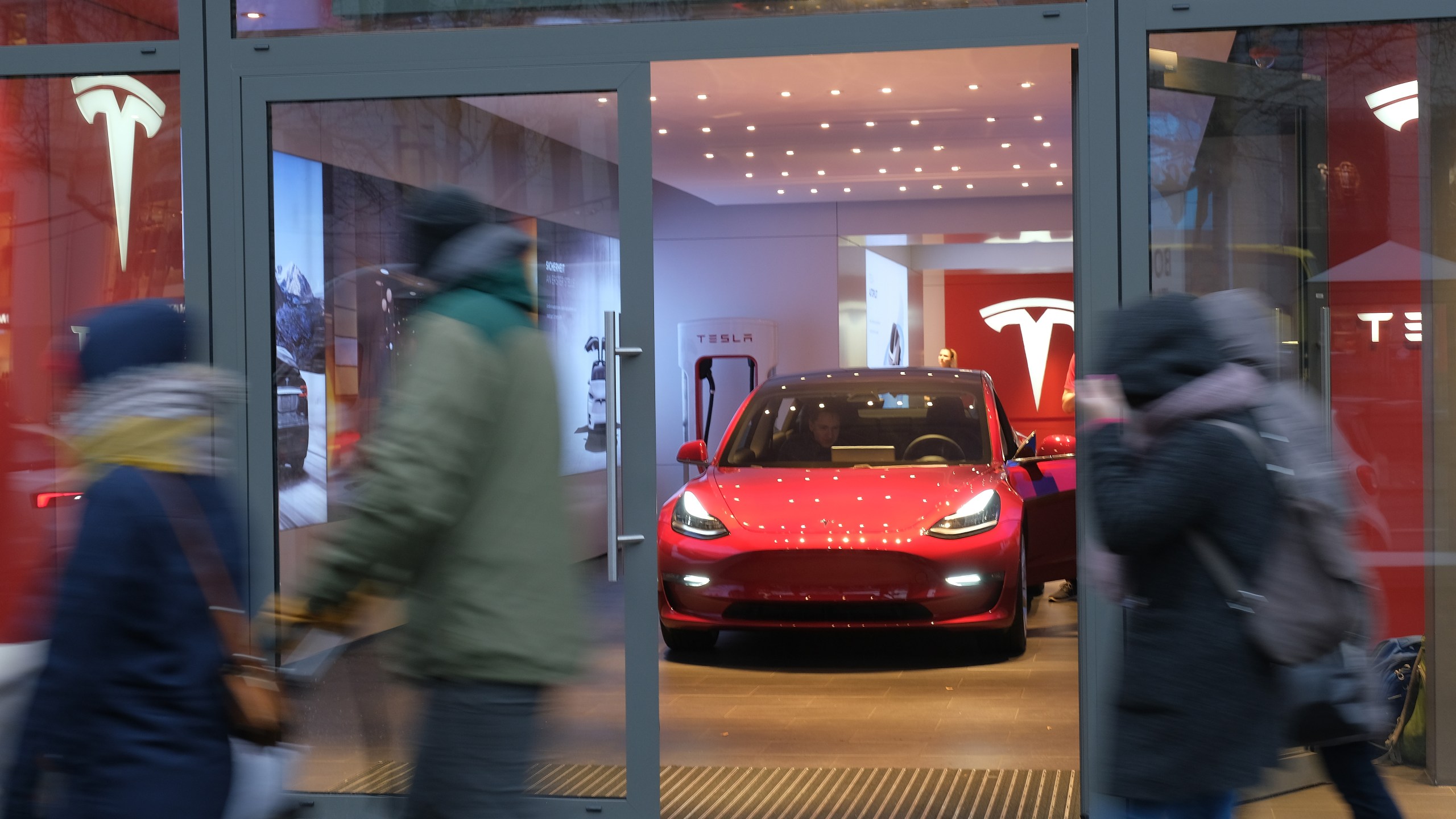 People walk past a Tesla dealership on in Berlin, Germany, on Jan. 4, 2019. (Credit: Sean Gallup / Getty Images)