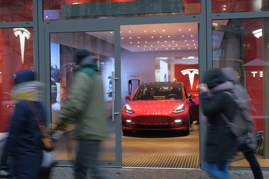 People walk past a Tesla dealership on in Berlin, Germany, on Jan. 4, 2019. (Credit: Sean Gallup / Getty Images)