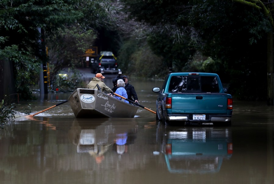 Residents use a boat to navigate floodwaters on Feb. 15, 2019 in Guerneville, Calif. An atmospheric river, a narrow corridor of concentrated moisture in the atmosphere, is bringing heavy rains to Northern California that is causing rivers to overflow their banks and flood many areas around the Russian River. (Credit: Justin Sullivan/Getty Images)