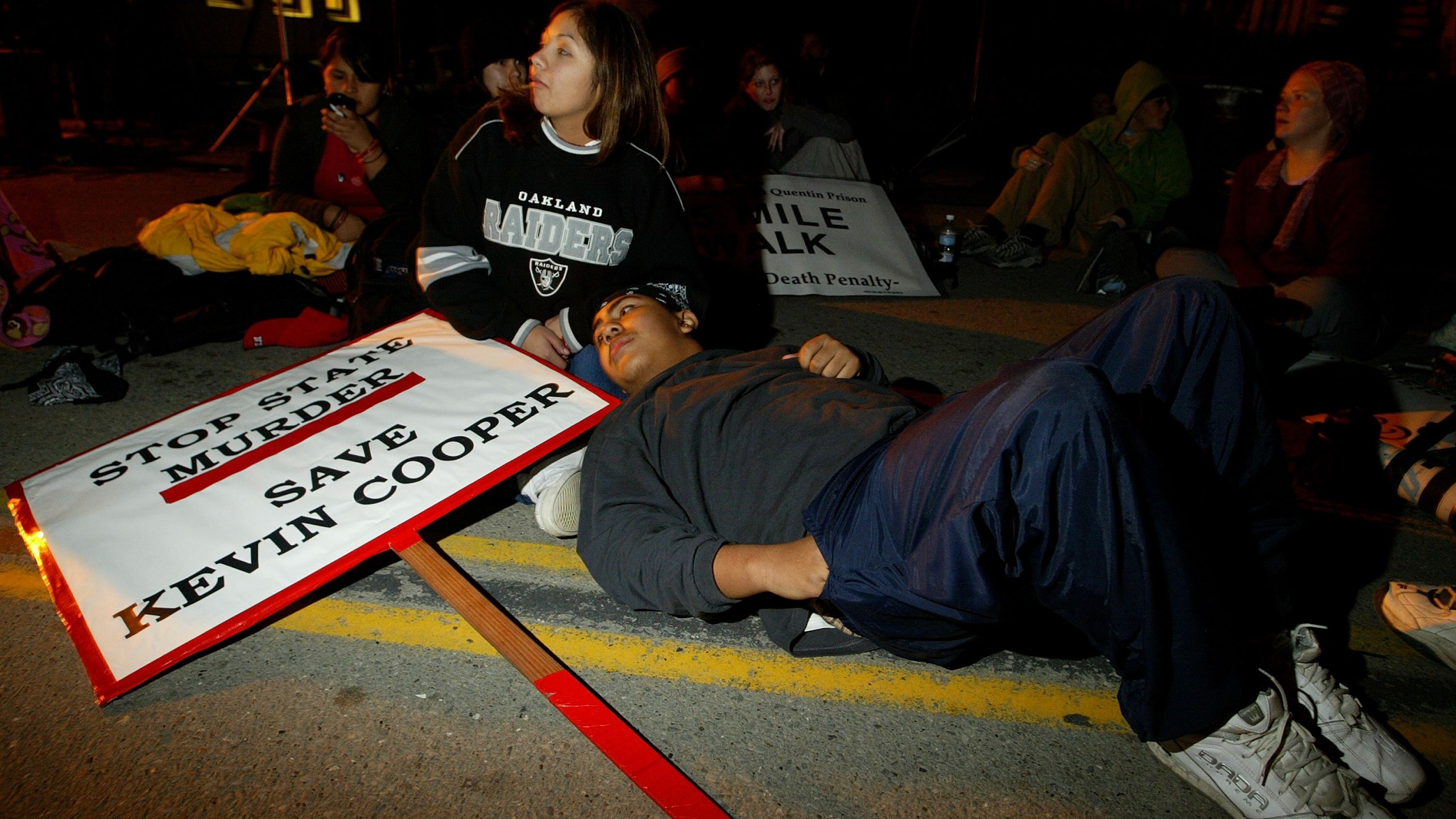 Muranda Jacques and Leo Lopez of San Jose rest outside of California State Prison at San Quentin on Feb. 9, 2004, as they protested in opposition to the execution of convicted killer Kevin Cooper. (Credit: Justin Sullivan/Getty Images)