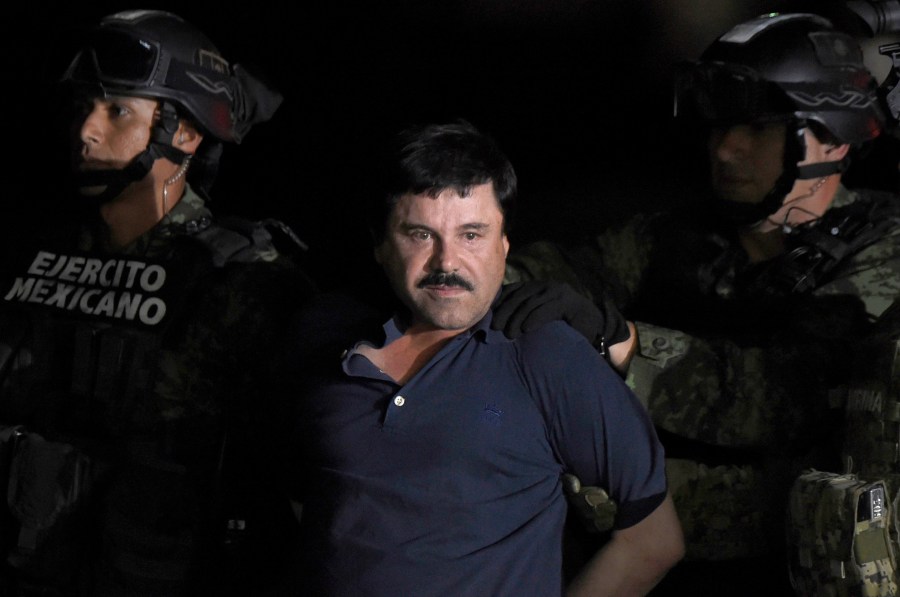 Joaquin "El Chapo" Guzman is escorted into a helicopter at Mexico City's airport on Jan. 8, 2016 following his recapture during an intense military operation in Los Mochis, in Sinaloa State. (Credit: ALFREDO ESTRELLA/AFP/Getty Images)