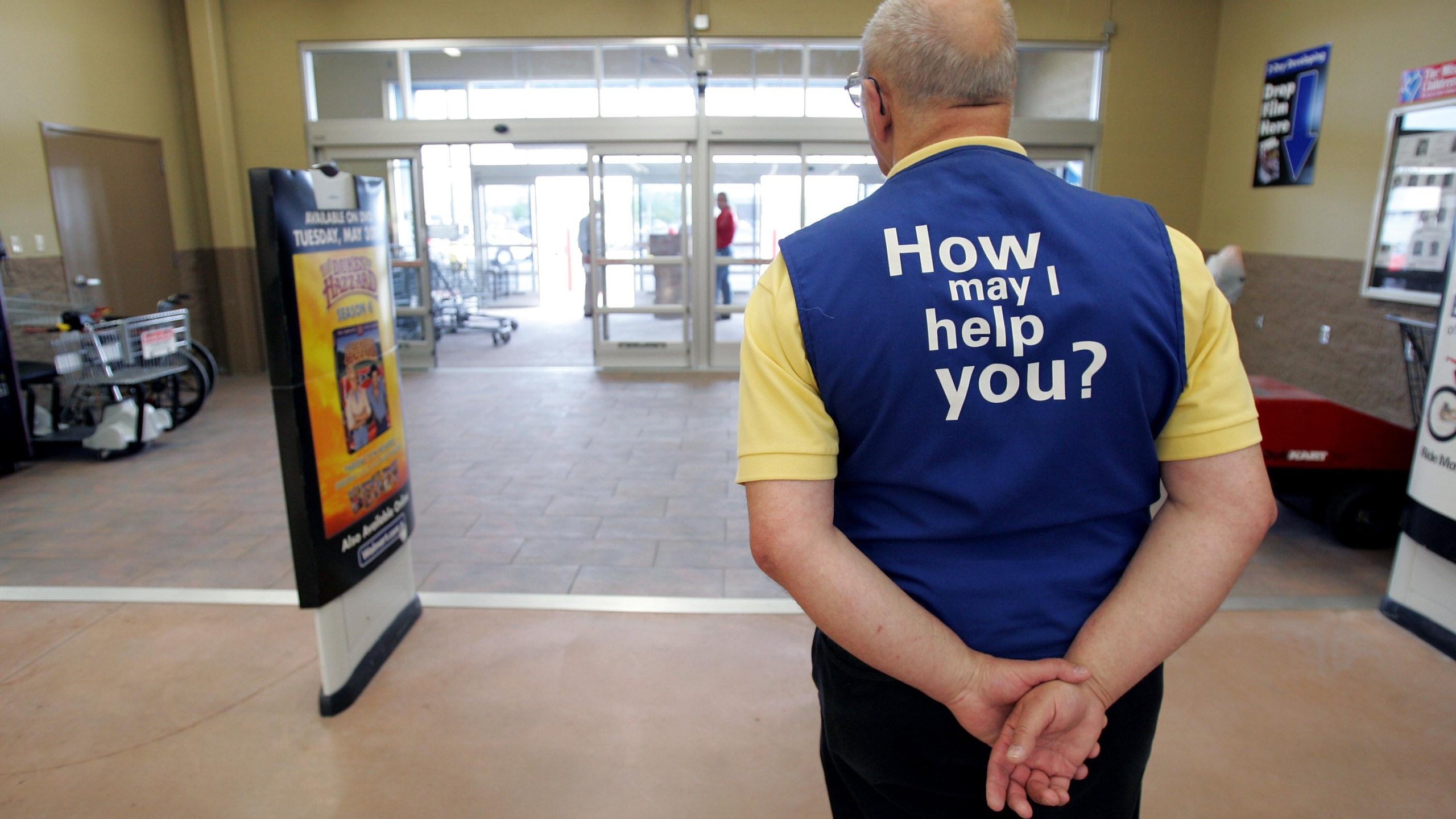 A Walmart greeter waits to welcome customers to the store in Bowling Green, Ohio, on May 17, 2006. (Credit: J.D. Pooley / Getty Images)