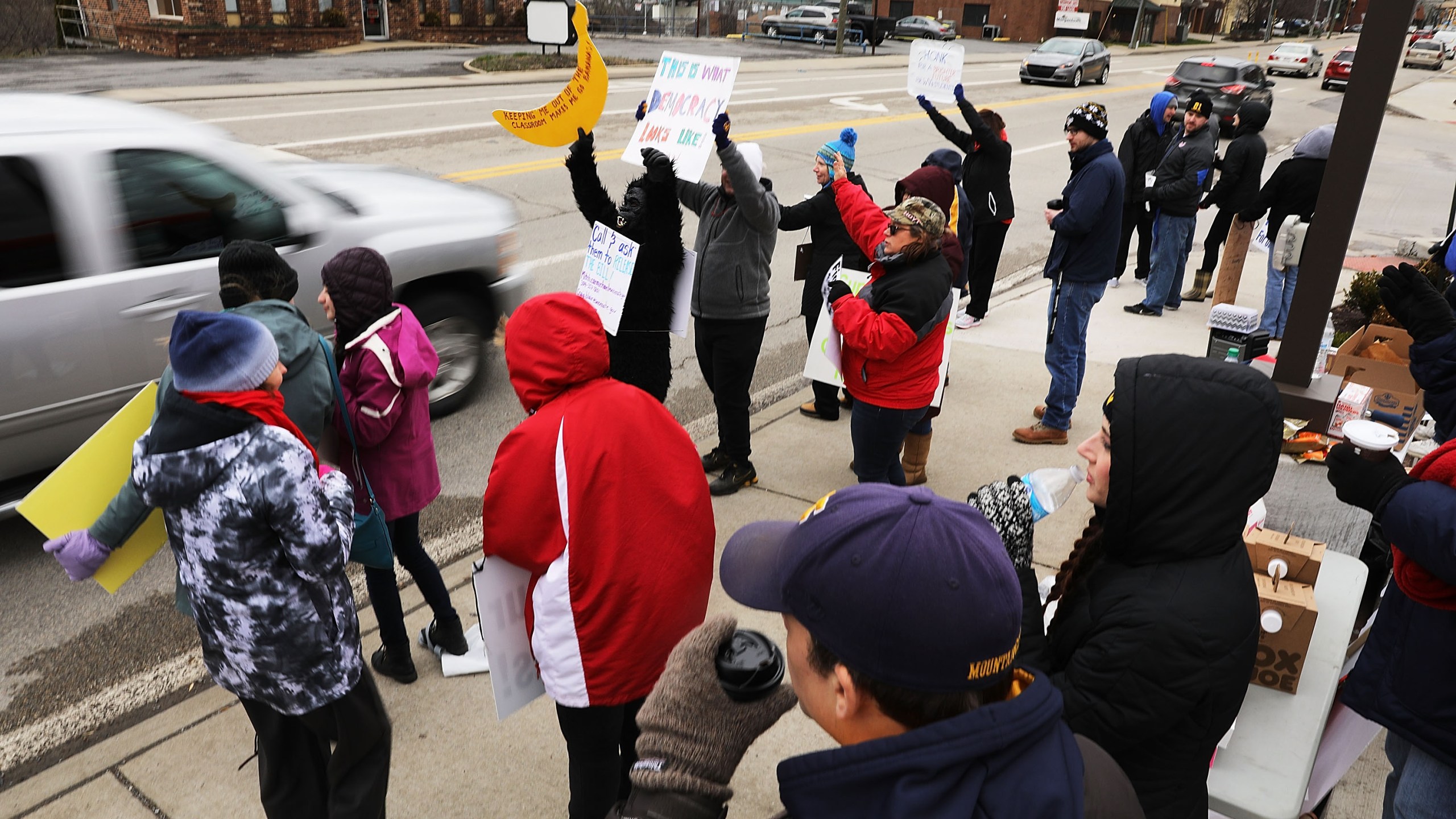 West Virginia teachers, students and supporters hold signs on a Morgantown street as they continue their strike on March 2, 2018 in Morgantown, West Virginia. (Credit: Spencer Platt/Getty Images)