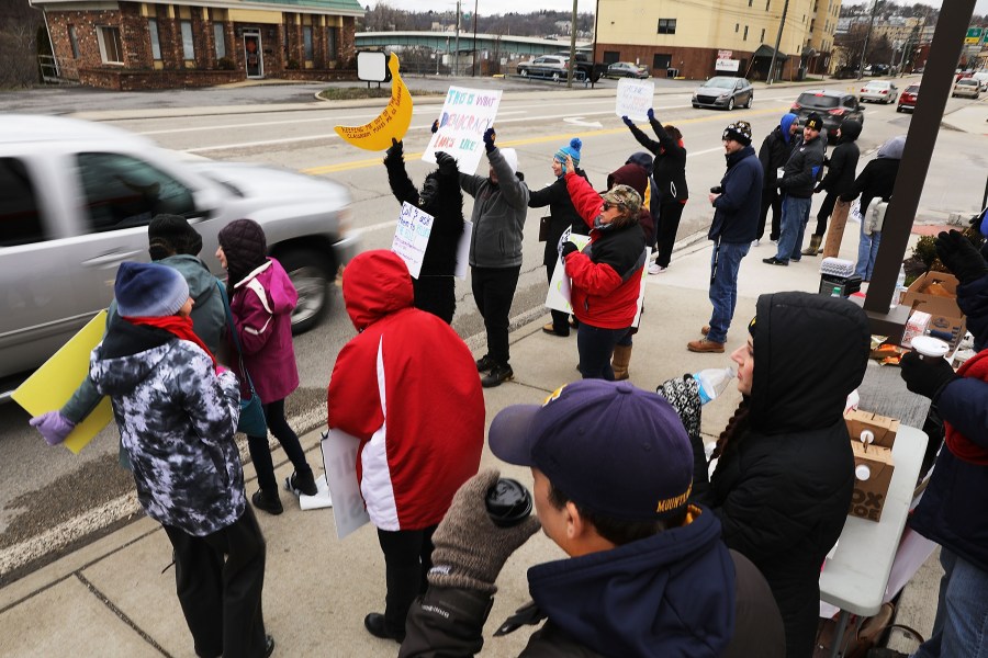 West Virginia teachers, students and supporters hold signs on a Morgantown street as they continue their strike on March 2, 2018 in Morgantown, West Virginia. (Credit: Spencer Platt/Getty Images)