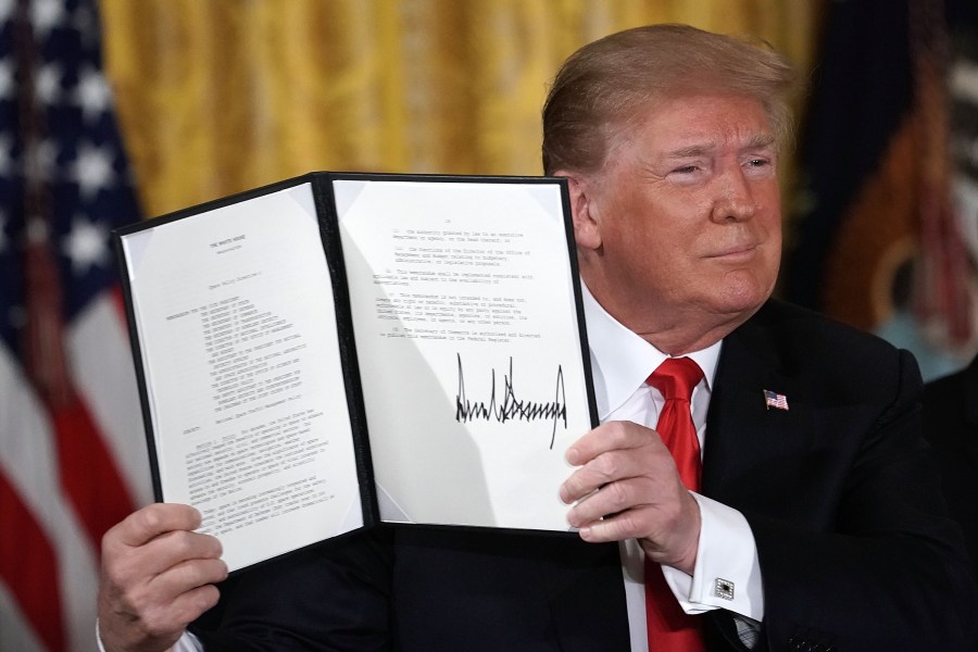 Donald Trump holds up an executive order that he signed during a meeting of the National Space Council at the East Room of the White House June 18, 2018 in Washington, D.C. (Credit: Alex Wong/Getty Images)