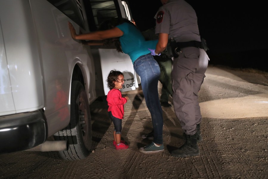 A two-year-old Honduran asylum seeker cries as her mother is searched and detained near the U.S.-Mexico border on June 12, 2018, in McAllen, Texas. (Credit: John Moore/Getty Images)