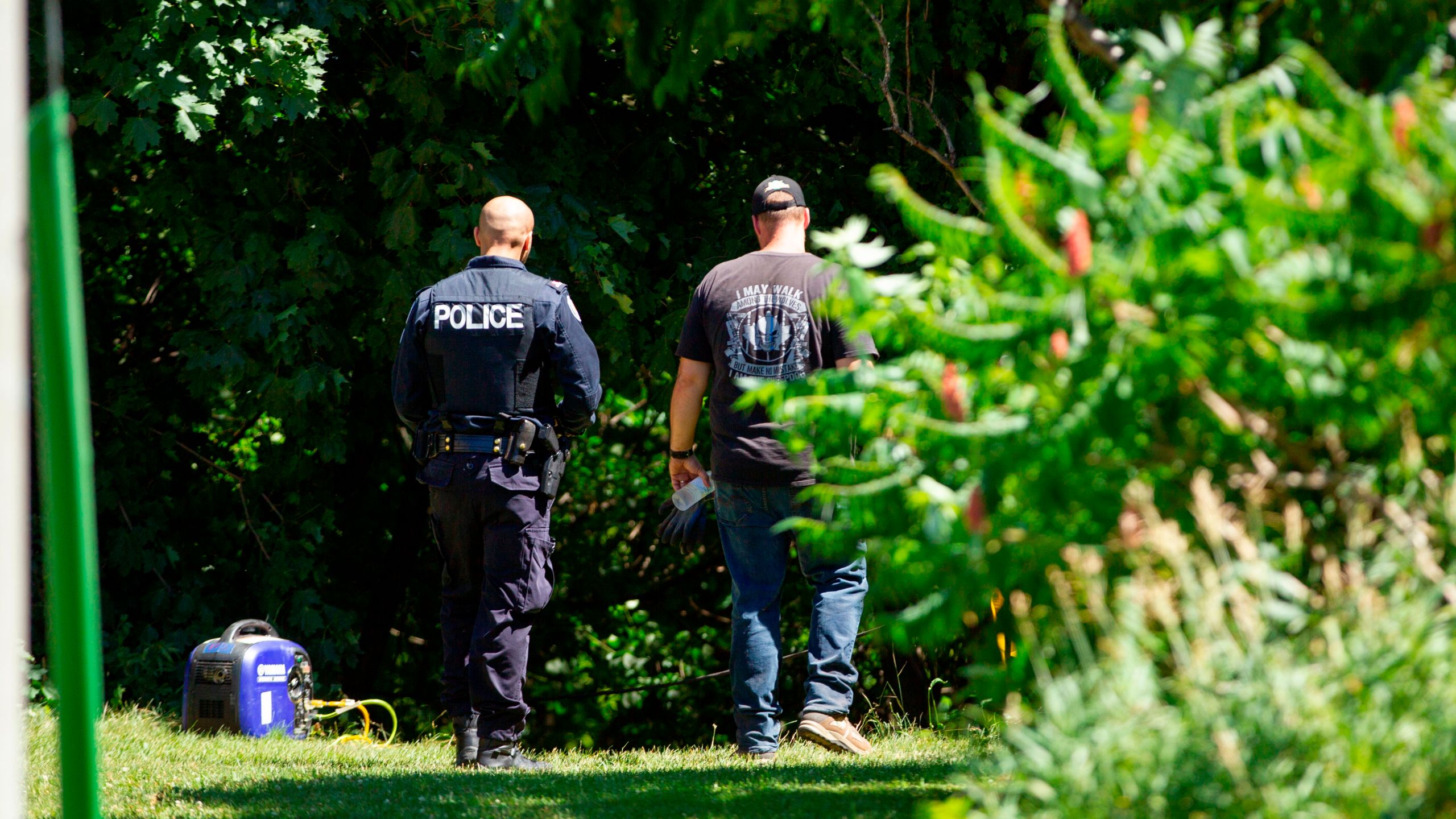 Investigators walk near a ravine behind a home on Mallory Crescent in Toronto, Ontario, July 6, 2018 where human remains were discovered in connection to the case of serial killer Bruce McArthur. (Credit: GEOFF ROBINS/AFP/Getty Images)