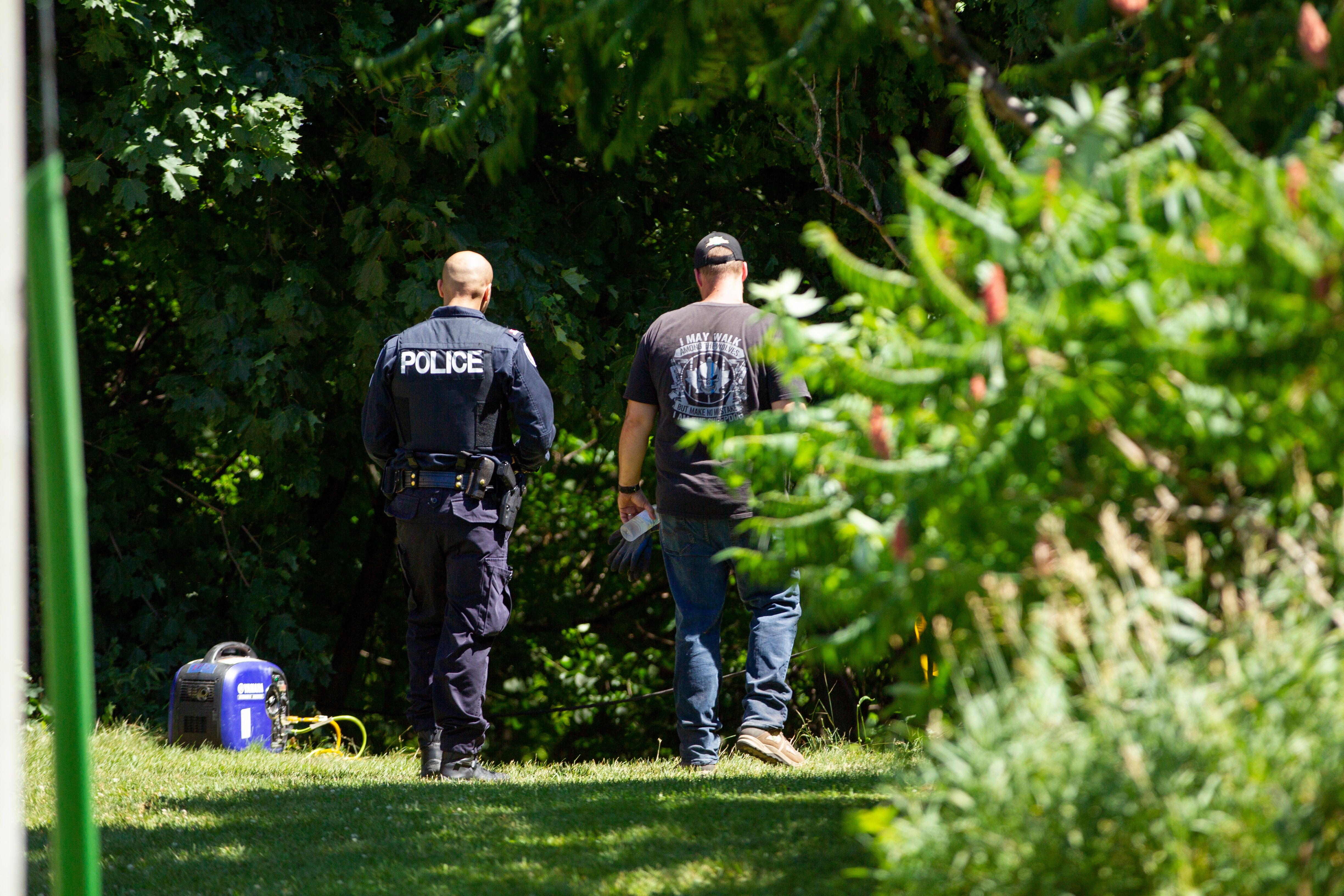 Investigators walk near a ravine behind a home on Mallory Crescent in Toronto, Ontario, July 6, 2018 where human remains were discovered in connection to the case of serial killer Bruce McArthur. (Credit: GEOFF ROBINS/AFP/Getty Images)