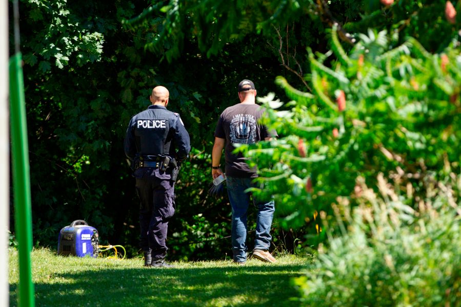 Investigators walk near a ravine behind a home on Mallory Crescent in Toronto, Ontario, July 6, 2018 where human remains were discovered in connection to the case of serial killer Bruce McArthur. (Credit: GEOFF ROBINS/AFP/Getty Images)