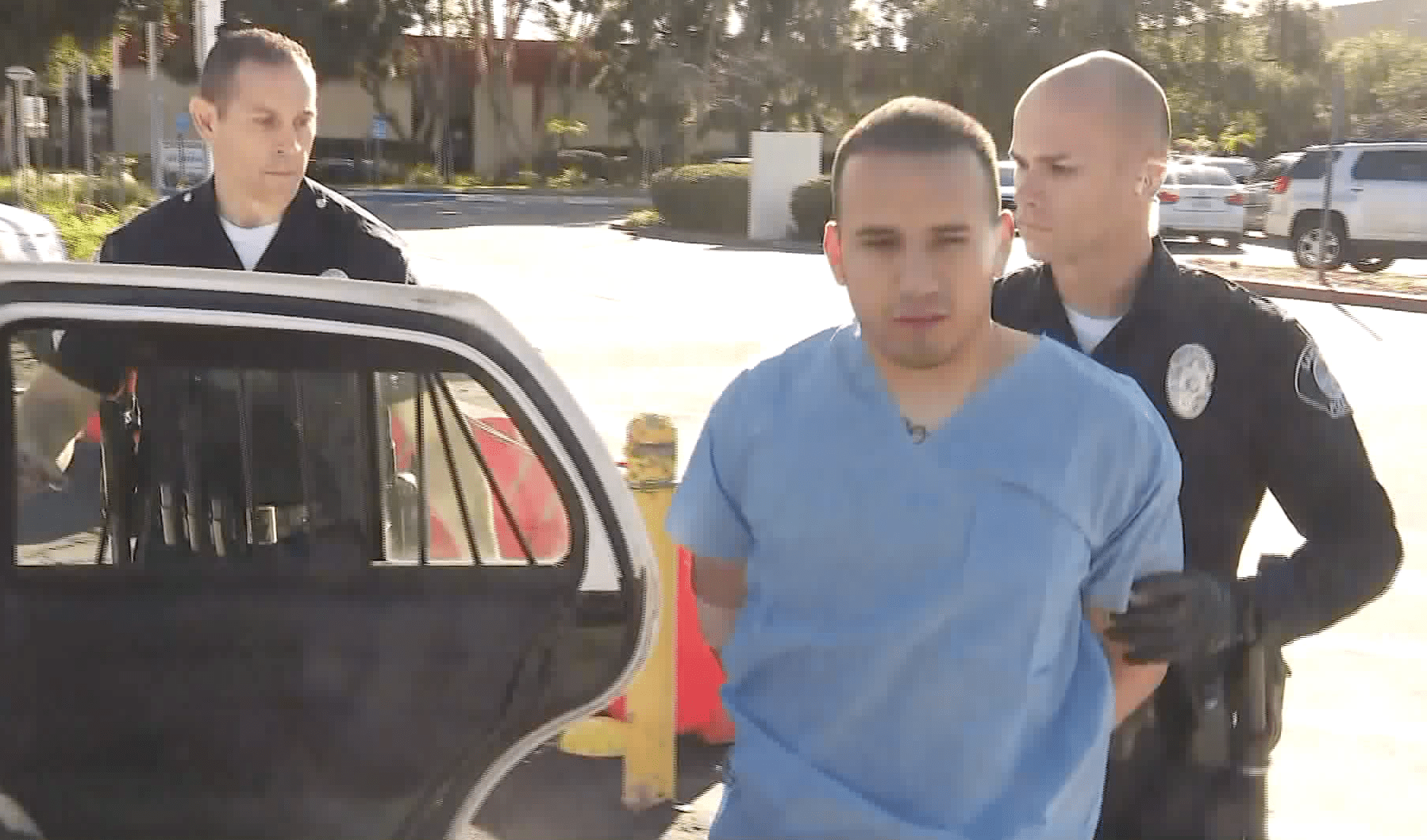 Officers place Vincent Michael Calvo into a patrol vehicle in Santa Ana on Feb. 17, 2019. (Credit: KTLA)