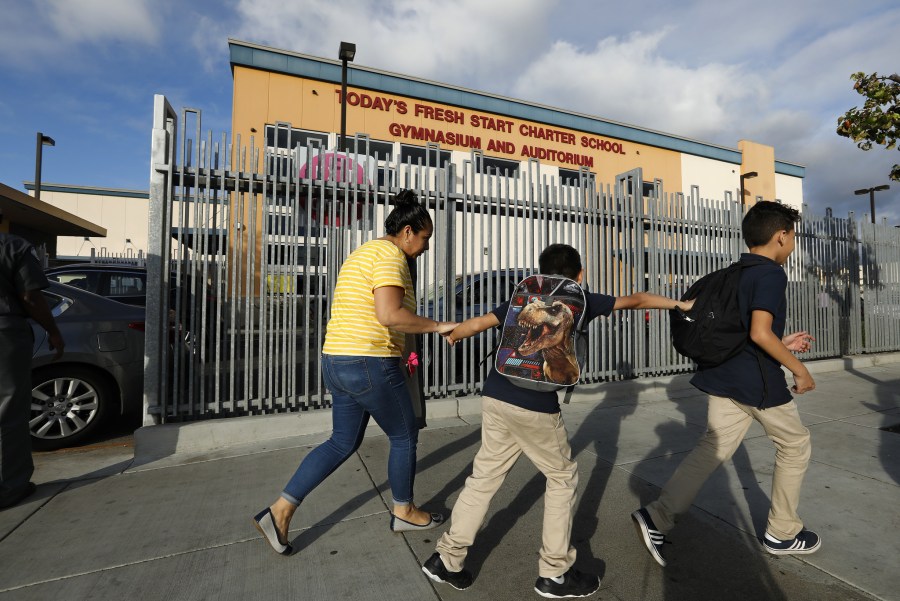 A parent and two students walk in front of Today’s Fresh Start's Inglewood campus in an undated photo. (Credit: Mel Melcon and Christina House / Los Angeles Times)