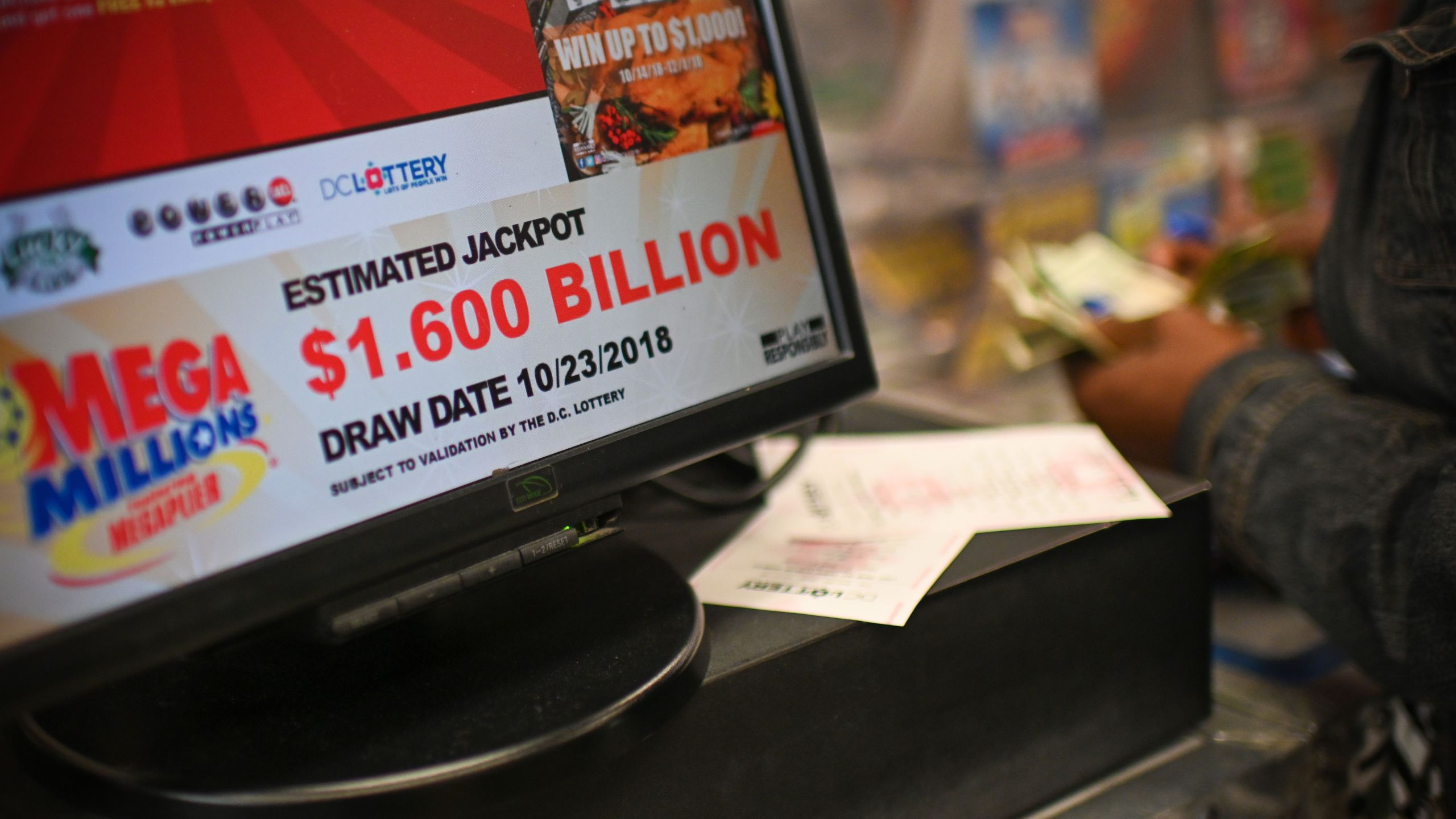 A woman buys Mega Millions tickets hours before the draw of the $1.6 billion jackpot, at a liquor store in downtown Washington D.C., on Oct. 23, 2018. (Credit: ERIC BARADAT/AFP/Getty Images)