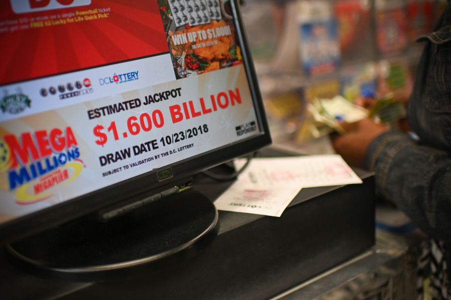 A woman buys Mega Millions tickets hours before the draw of the $1.6 billion jackpot, at a liquor store in downtown Washington D.C., on Oct. 23, 2018. (Credit: ERIC BARADAT/AFP/Getty Images)