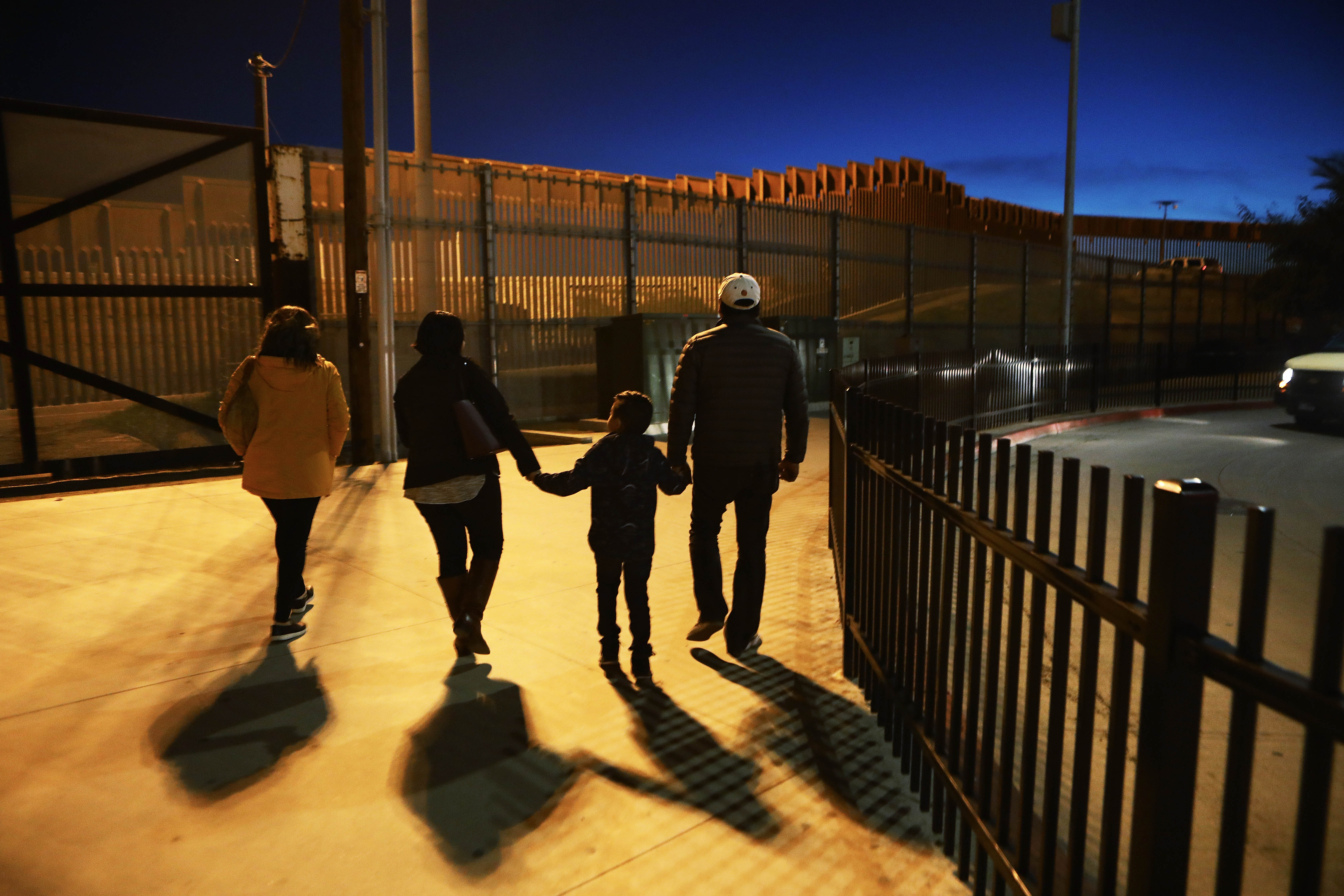 People walk on a sidewalk on the U.S. side of the U.S.-Mexico border barrier in San Diego on Jan. 25, 2019. (Credit: Mario Tama / Getty Images)