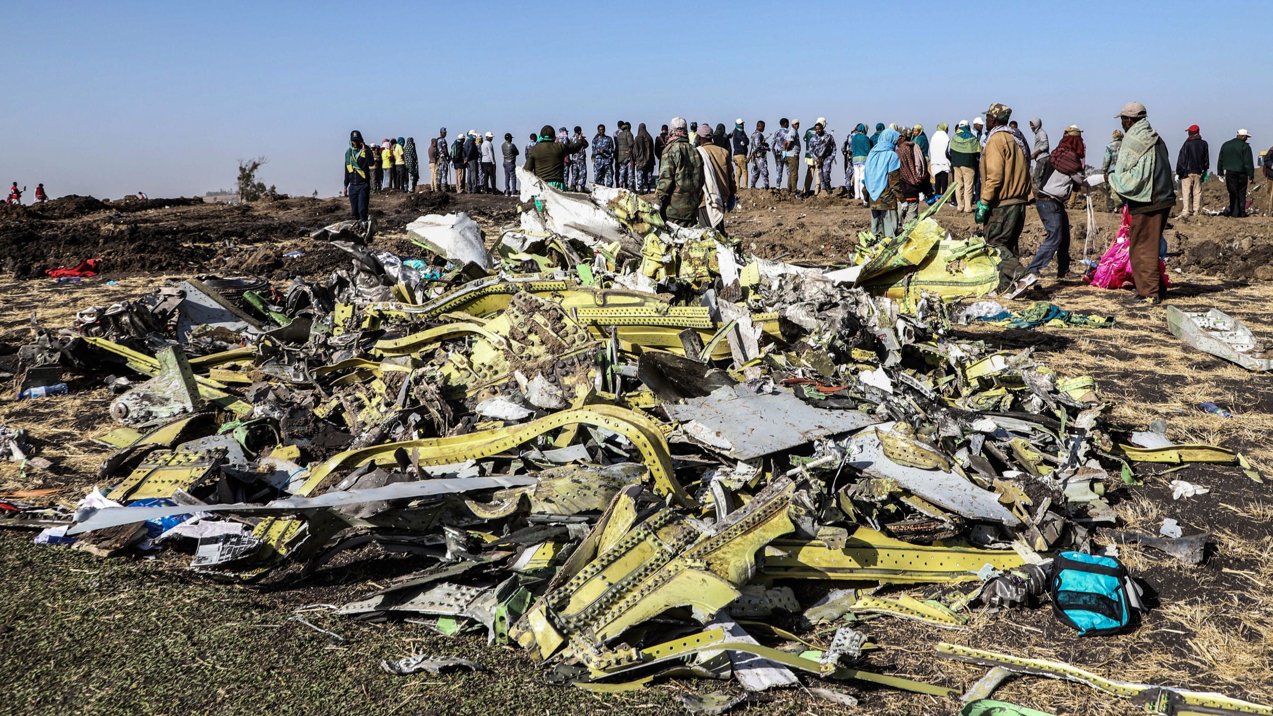 People stand near collected debris at the crash site of Ethiopia Airlines near Bishoftu, a town some 60 kilometres southeast of Addis Ababa, Ethiopia, on March 11, 2019. (Credit: MICHAEL TEWELDE/AFP/Getty Images)