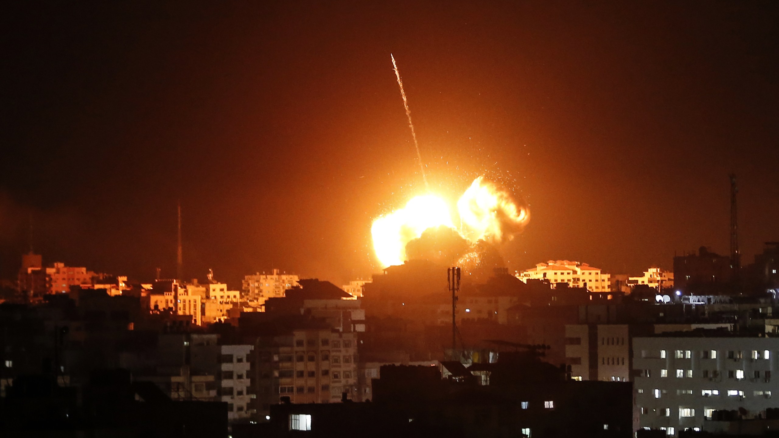 A ball of fire lights the sky above buildings in Gaza on March 25, 2019. (Credit: MAHMUD HAMS/AFP/Getty Images)