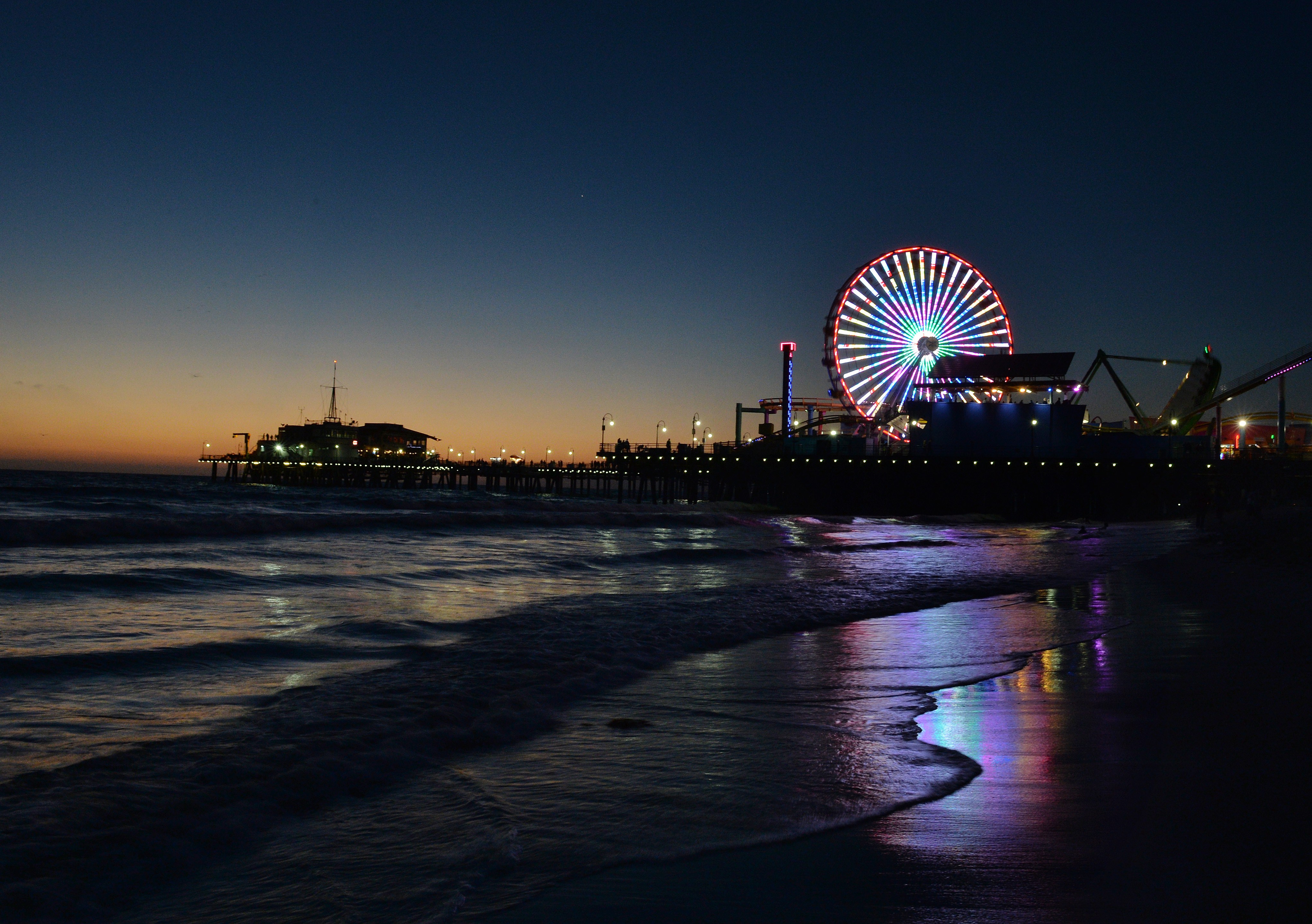 The sun sets over the Pacific Amusement Park at Santa Monica pier on Oct. 19, 2014. (Credit: Mark Ralston/AFP/Getty Images)