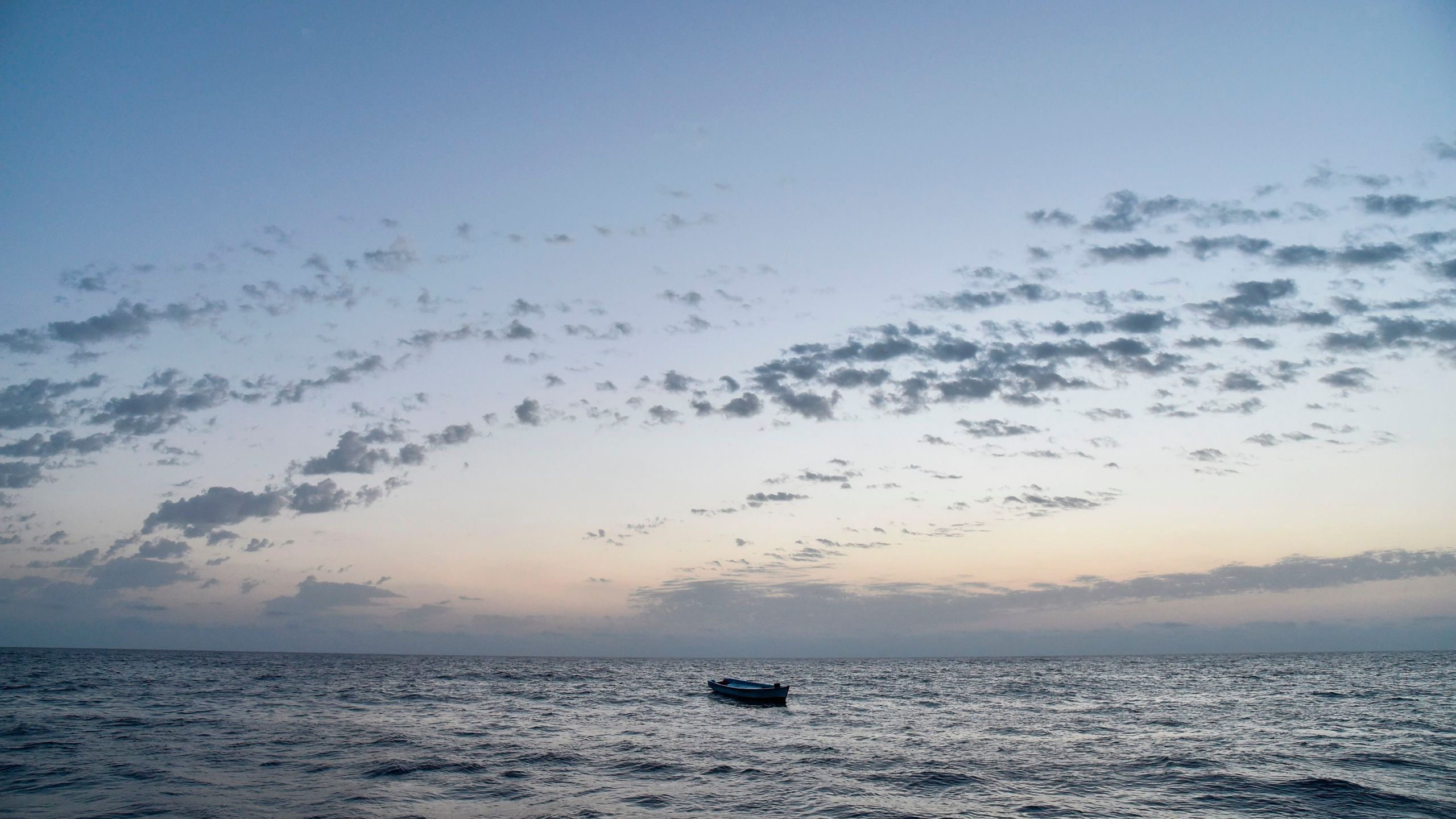 A small wooden boat used by migrants to cross the Mediterranean Sea is abandoned after a rescue operation on November 3, 2016, off the Libyan coast. (Credit: ANDREAS SOLARO/AFP/Getty Images)