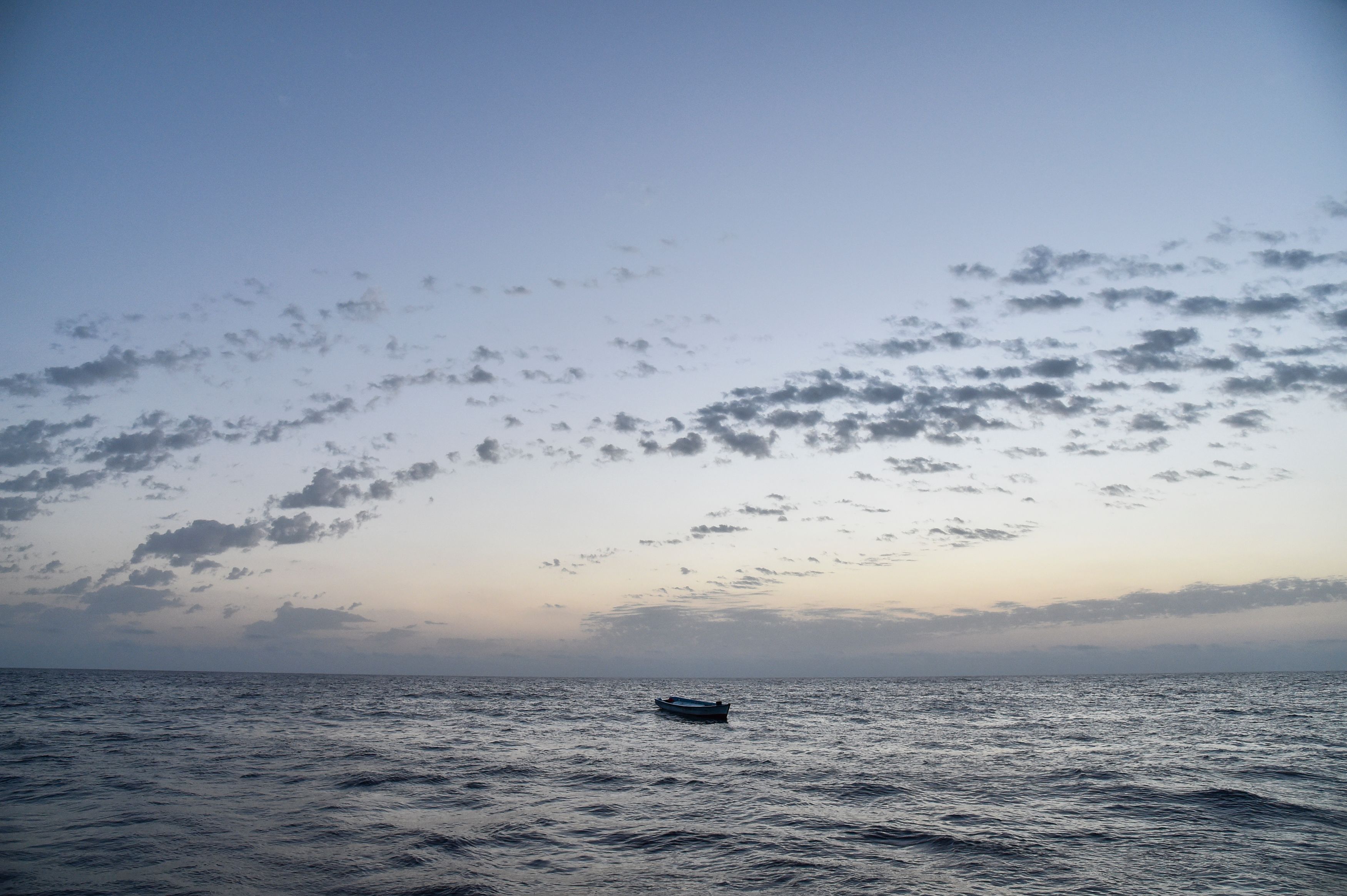 A small wooden boat used by migrants to cross the Mediterranean Sea is abandoned after a rescue operation on November 3, 2016, off the Libyan coast. (Credit: ANDREAS SOLARO/AFP/Getty Images)