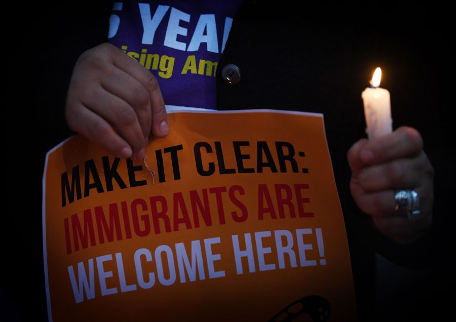 Migrant rights groups hold candles during a vigil to protest against Donald Trump's crackdown on "sanctuary cities" outside the City Hall in Los Angeles on Jan. 25, 2017.