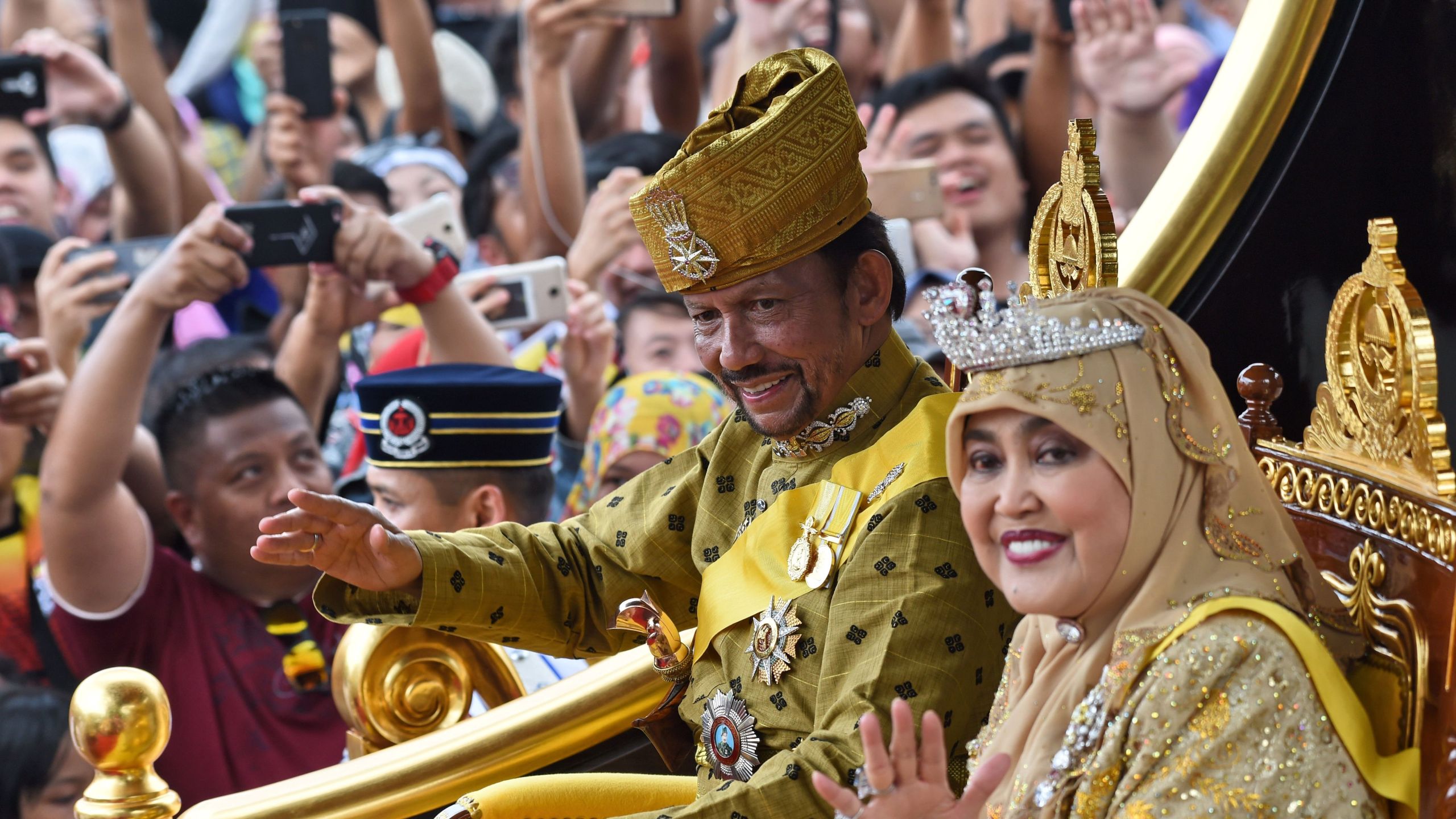 Brunei's Sultan Hassanal Bolkiah and Queen Saleha ride in a royal chariot during a procession to mark his golden jubilee of accession to the throne in Bandar Seri Begawan on October 5, 2017. (Credit: Roslan Rahman/AFP/Getty Images)