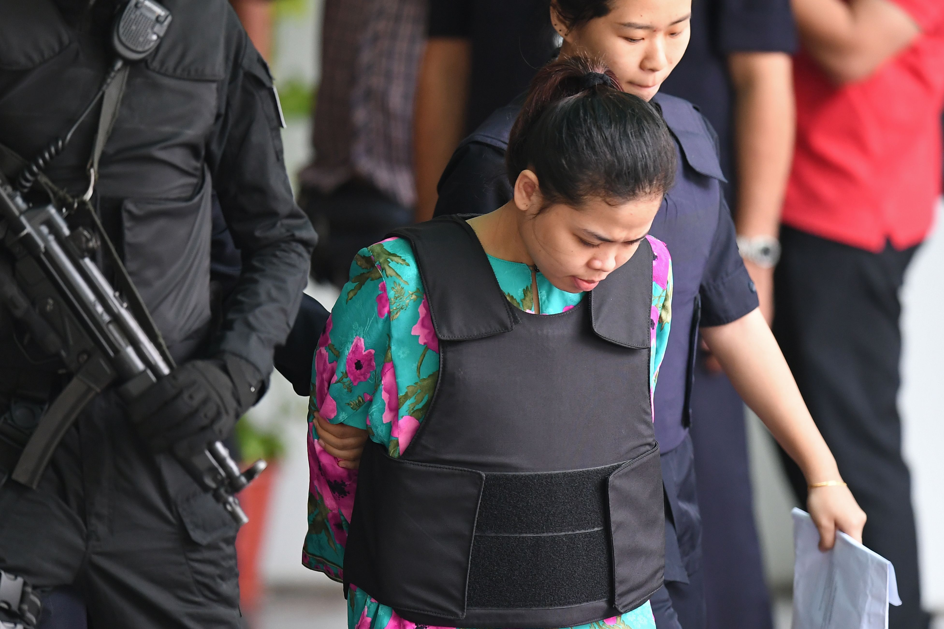 Indonesian defendant Siti Aisyah is escorted by police personnel following her appearance at the Malaysian Chemistry Department in Petaling Jaya, outside Kuala Lumpur on October 9, 2017. (Credit: Mohd Rasfan/AFP/Getty Images)