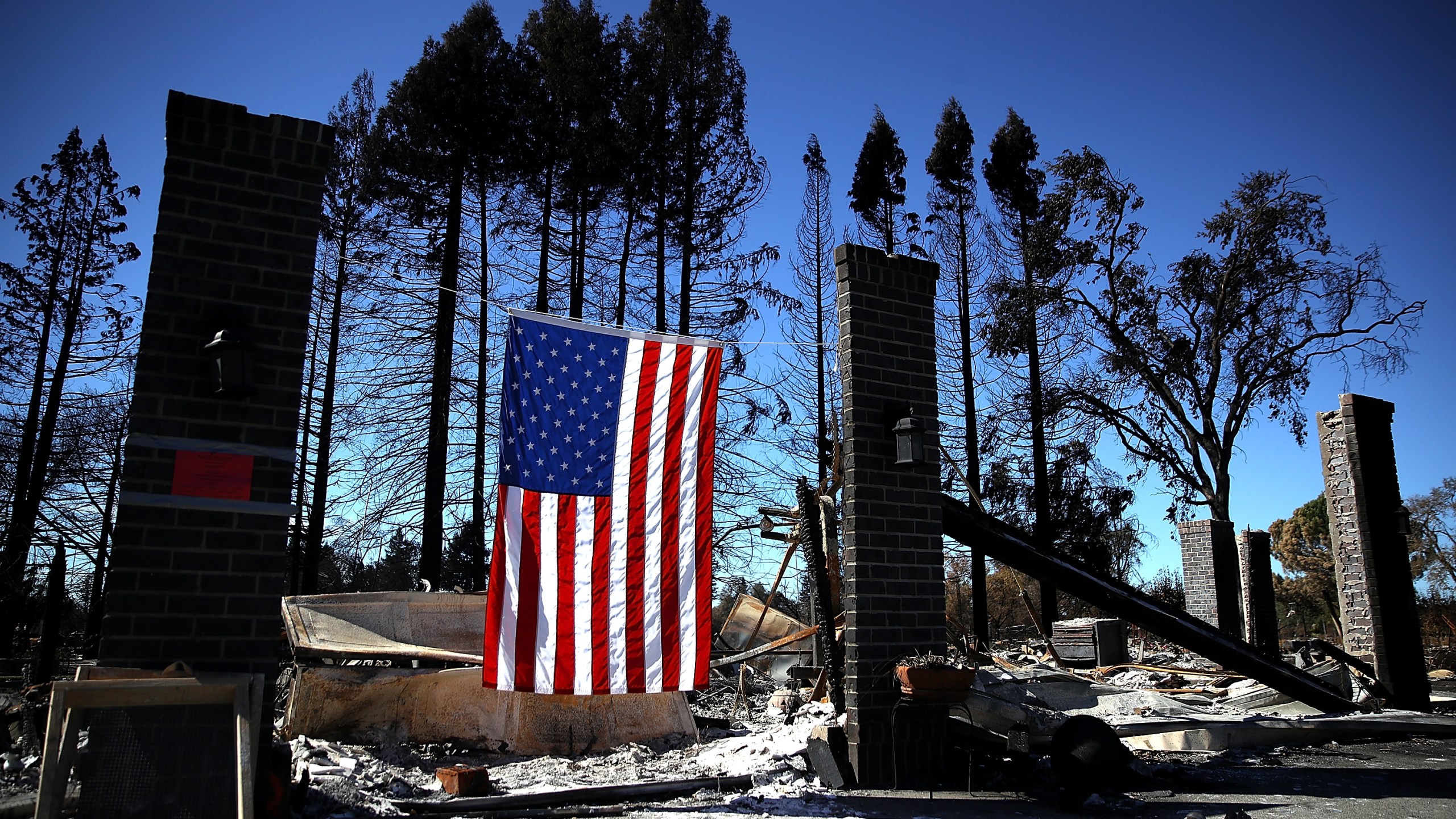 An American flag hangs in front of a home in the Coffey Park neighborhood that was destroyed by the Tubbs Fire on Oct. 23, 2017, in Santa Rosa. (Credit: Justin Sullivan/Getty Images)