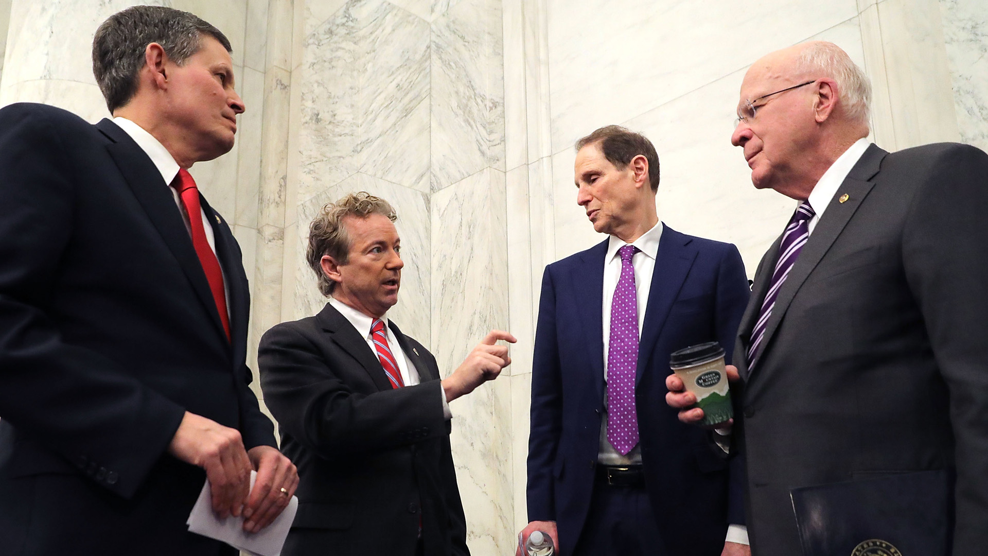 (L-R) Sen. Steve Daines (R-MT), Sen. Rand Paul (R-KY), Sen. Ron Wyden (D-OR) and Sen. Patrick Leahy (D-VT) talk strategy before a news conference about their proposed reforms to the Foreign Intelligence Surveillance Act in the Russell Senate Office Building on Capitol Hill January 16, 2018 in Washington, DC. (Credit: Chip Somodevilla/Getty Images)