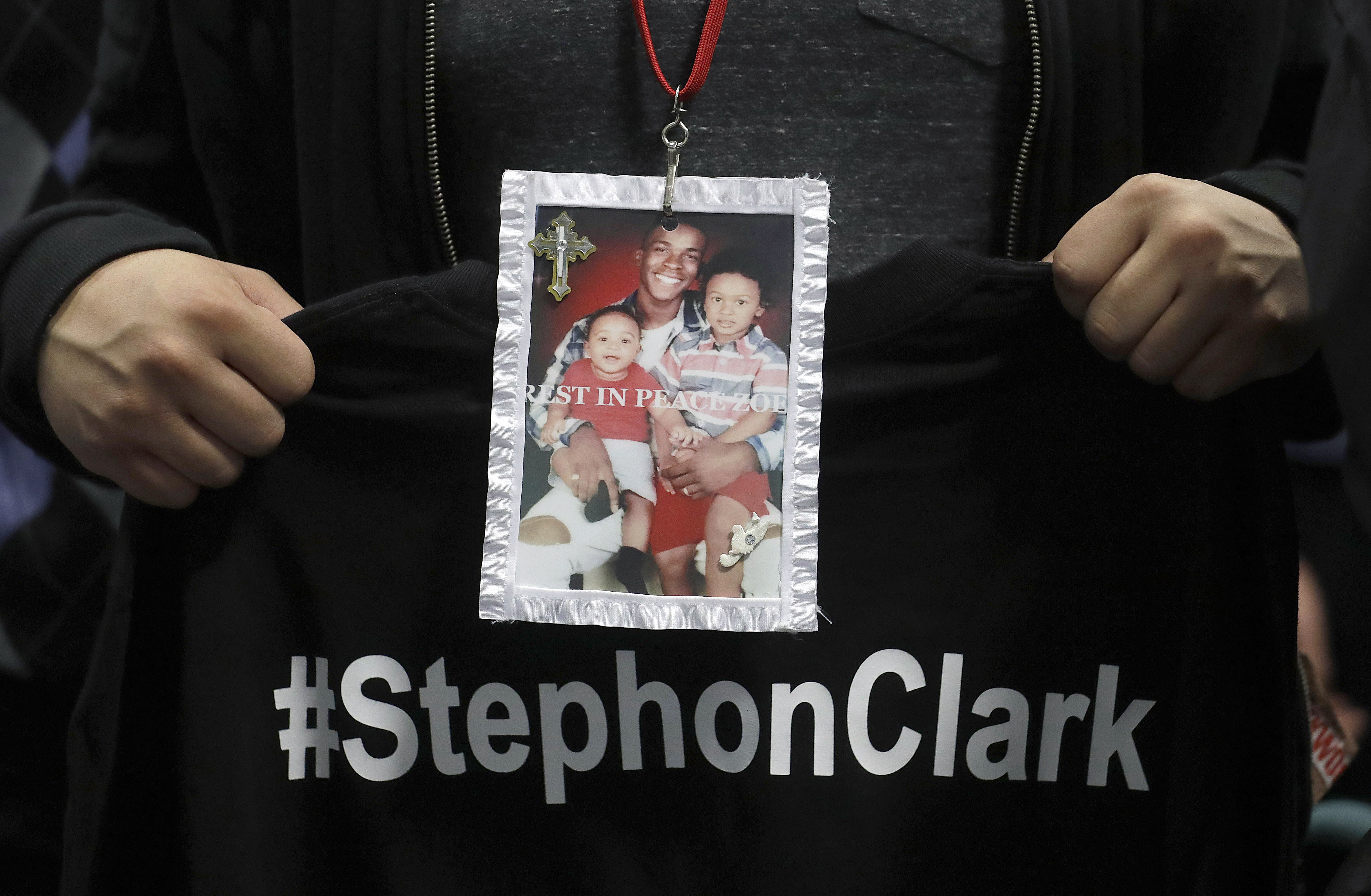 A mourner holds up a photo of police shooting victim Stephon Clark during funeral services at the Bayside Of South Sacramento Church March 29, 2018 in Sacramento. (Credit: Jeff Chiu-Pool/Getty Images)