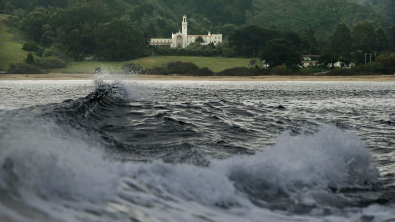 Waves break at Monastery Beach, with the Chapel of the Carmelite Monastery in the background, in Carmel in this 2013 file photo. (Credit: Mark Boster / Los Angeles Times)