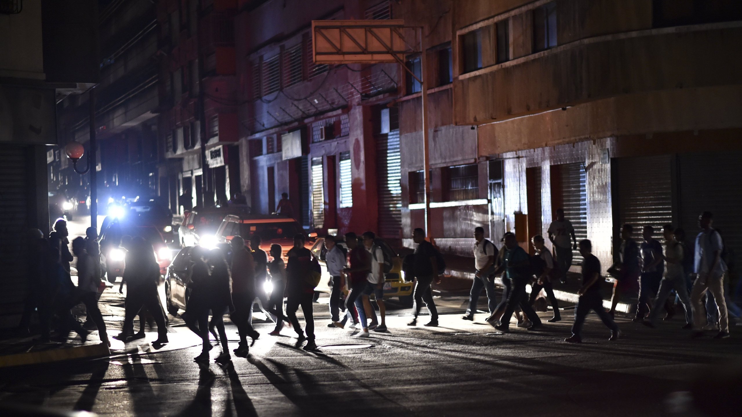 People cross a street during a power cut in Caracas, Venezuela, on March 7, 2019. (Credit: Yuri Cortez/AFP/Getty Images)