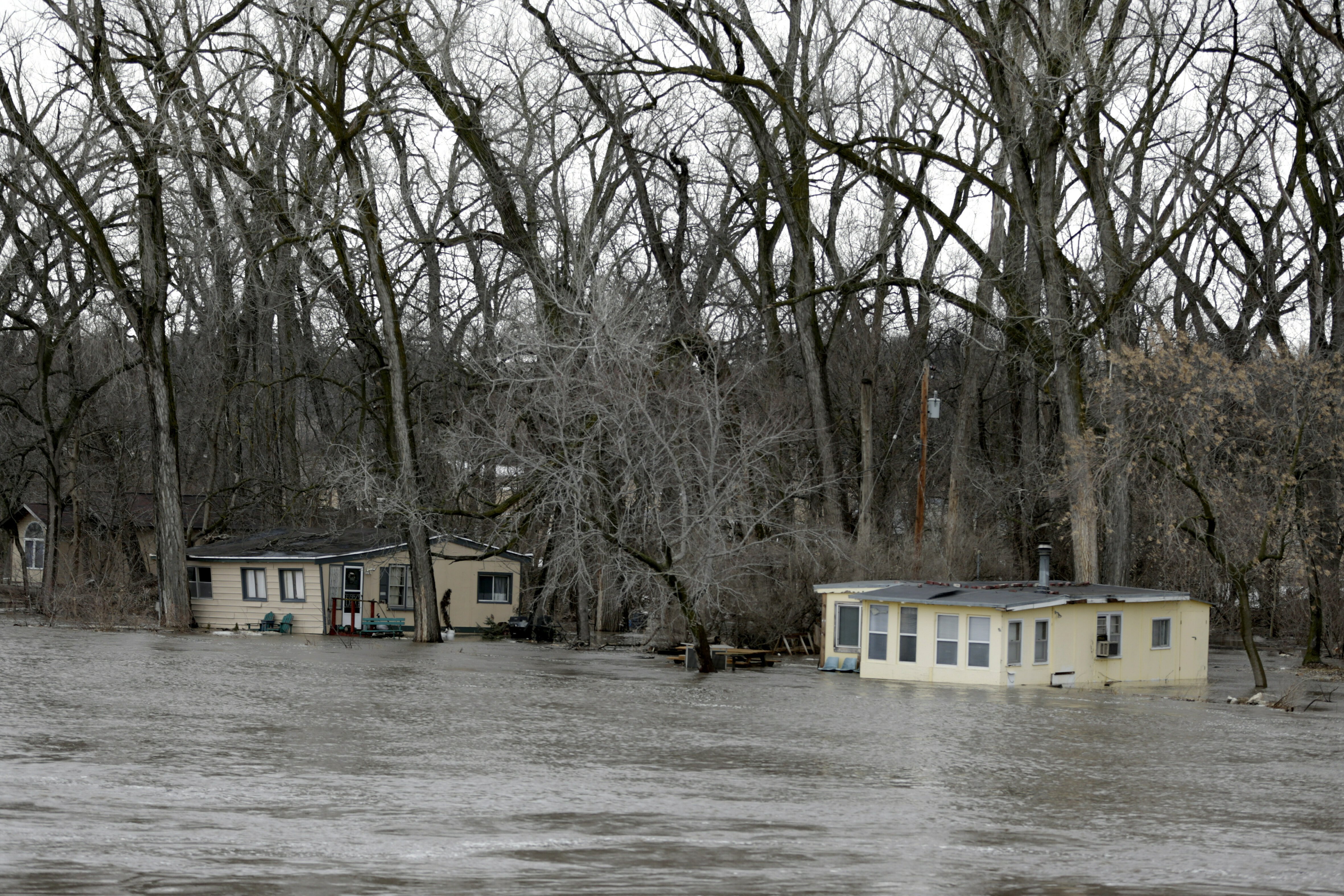 The rising waters of the Elkhorn River south of Arlington, Neb., Thursday, March 14, 2019, floods cabins. Evacuations forced by flooding have occurred in several eastern Nebraska communities. (Credit: CNN)