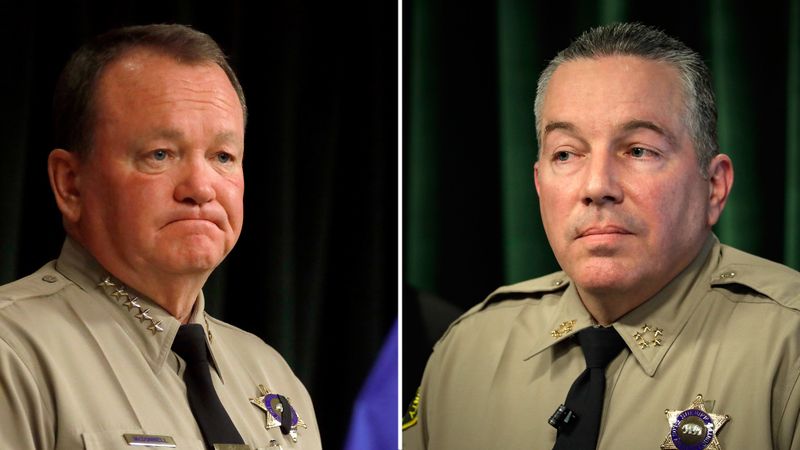 In July 2018, then-Sheriff Jim McDonnell, left, launched a study of cliques with matching tattoos. Current Sheriff Alex Villaneuva has downplayed the significance of deputies with matching tattoos. The two men are seen in undated file photos. (Credit: Los Angeles Times)