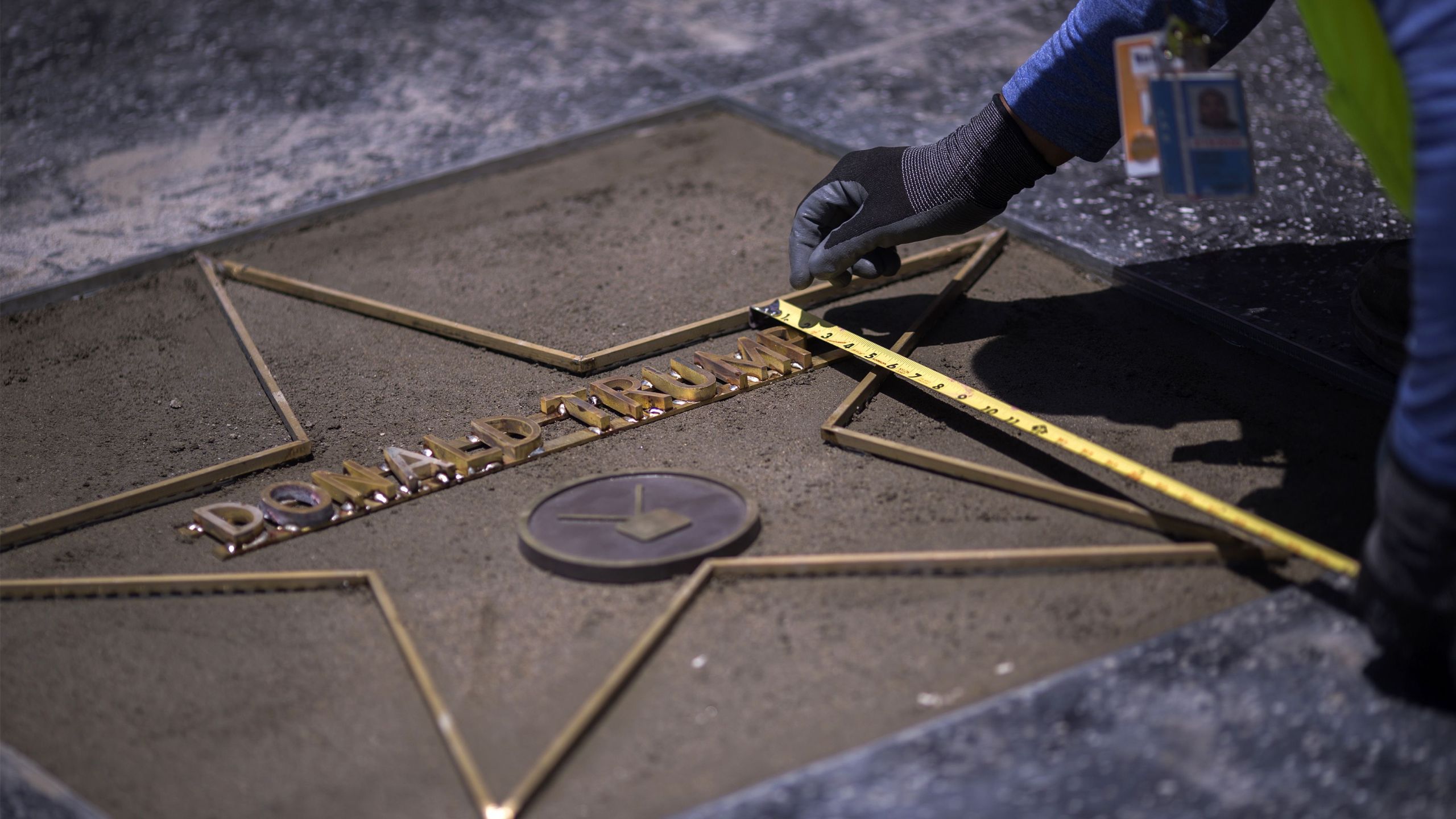 Workers replace the star of President Donald J. Trump on the Hollywood Walk of Fame after it was destroyed by a vandal in the early morning hours on July 25, 2018 in Los Angeles. (Credit: DAVID MCNEW/AFP/Getty Images)