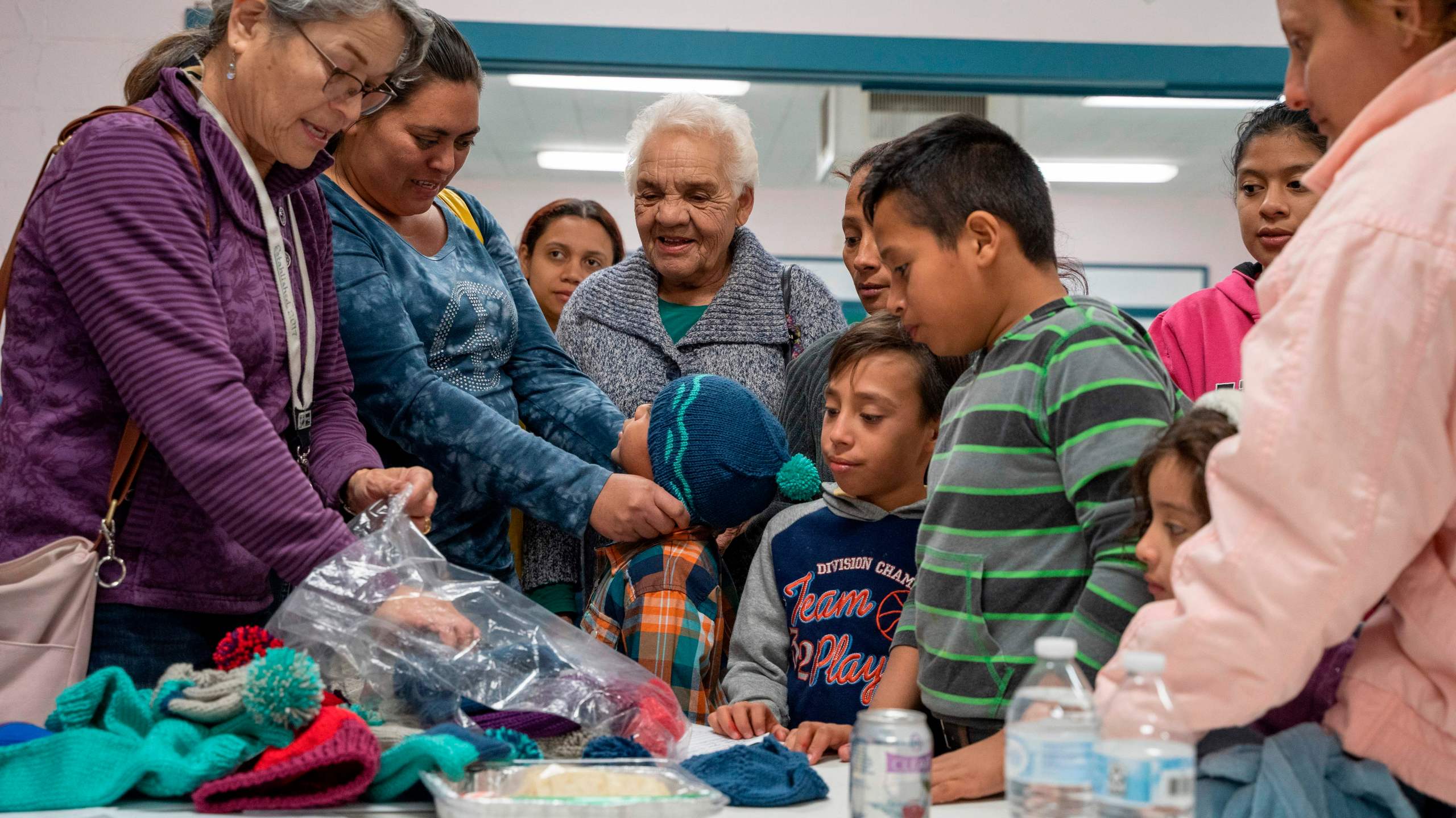 Volunteers hand out knitted hats for Central American migrant families at the Immaculate Heart of Mary Catholic Church in Las Cruces, New Mexico on Dec. 21, 2018. (Credit: PAUL RATJE/AFP/Getty Images)