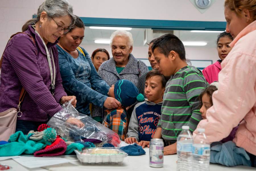 Volunteers hand out knitted hats for Central American migrant families at the Immaculate Heart of Mary Catholic Church in Las Cruces, New Mexico on Dec. 21, 2018. (Credit: PAUL RATJE/AFP/Getty Images)