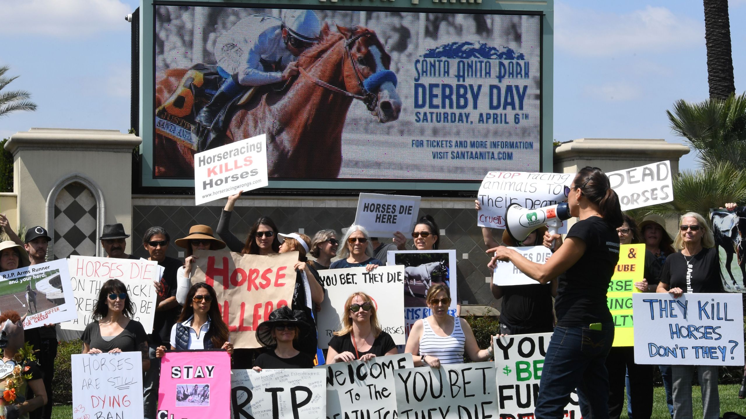 Animal-rights advocates protest beside the racetrack entrance gate after the deaths of 23 racehorses in the first three months of 2019 at the Santa Anita Park in Arcadia, April 6, 2019. (Credit: Mark Ralston / AFP / Getty Images)