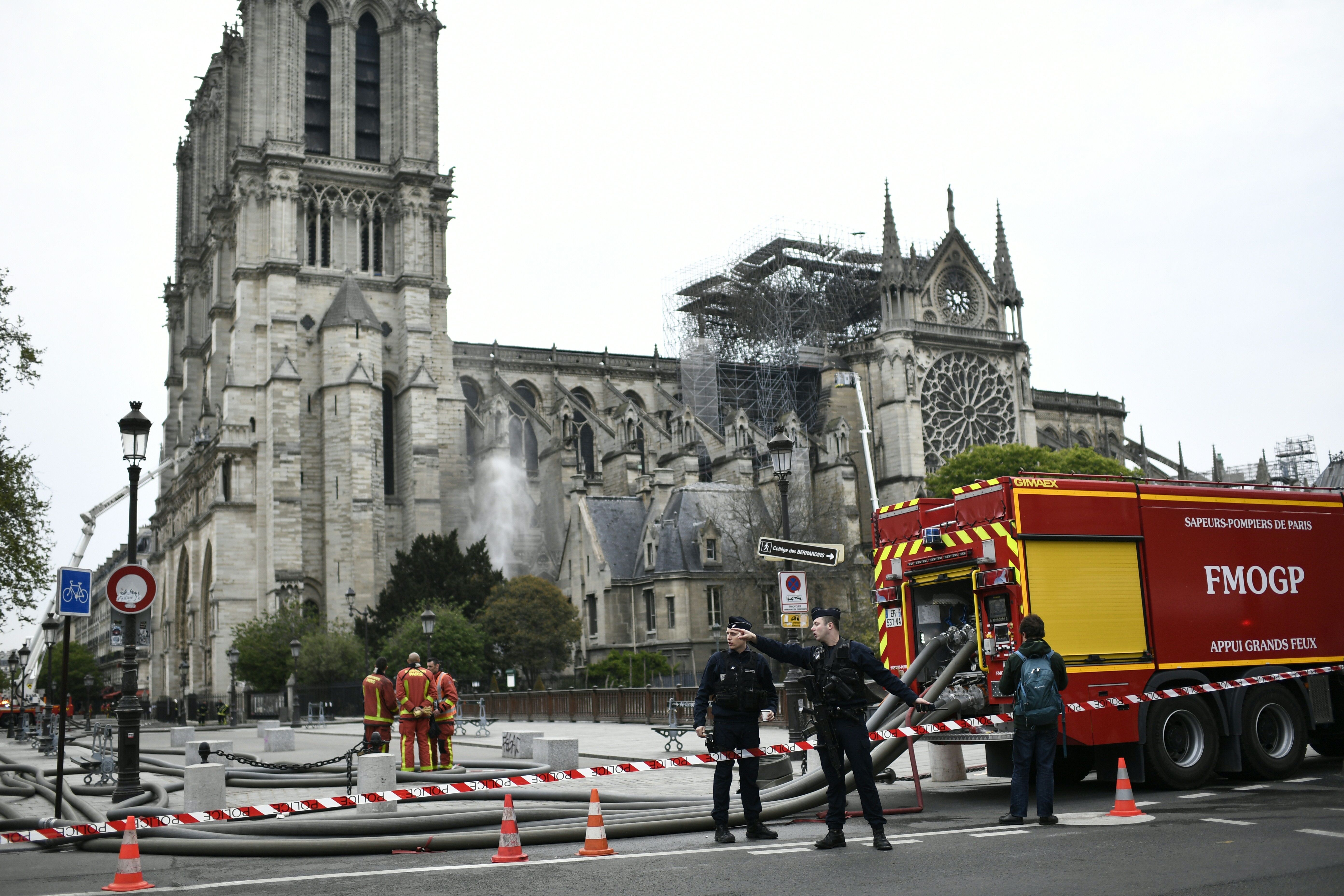 Firefighters continue to secure Notre-Dame Cathedral in Paris on April 16, 2019, in the aftermath of a fire that caused its spire to crash to the ground. (Credit: STEPHANE DE SAKUTIN/AFP/Getty Images)