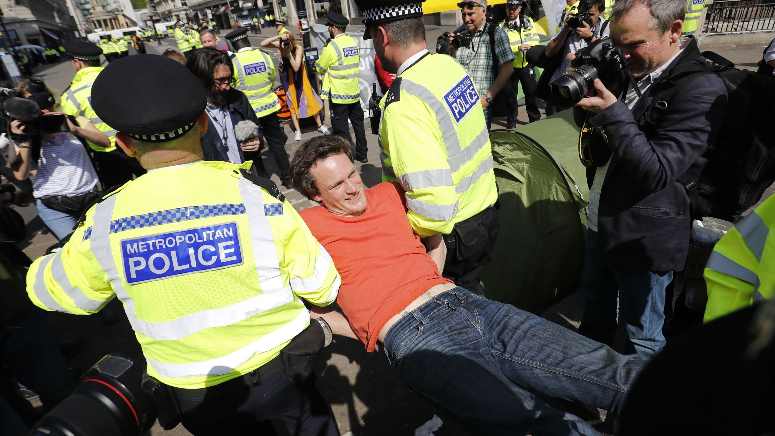 Police officers carry away a climate change activist who was occupying the road junction at Oxford Circus in central London on April 19, 2019. (Credit: TOLGA AKMEN/AFP/Getty Images)