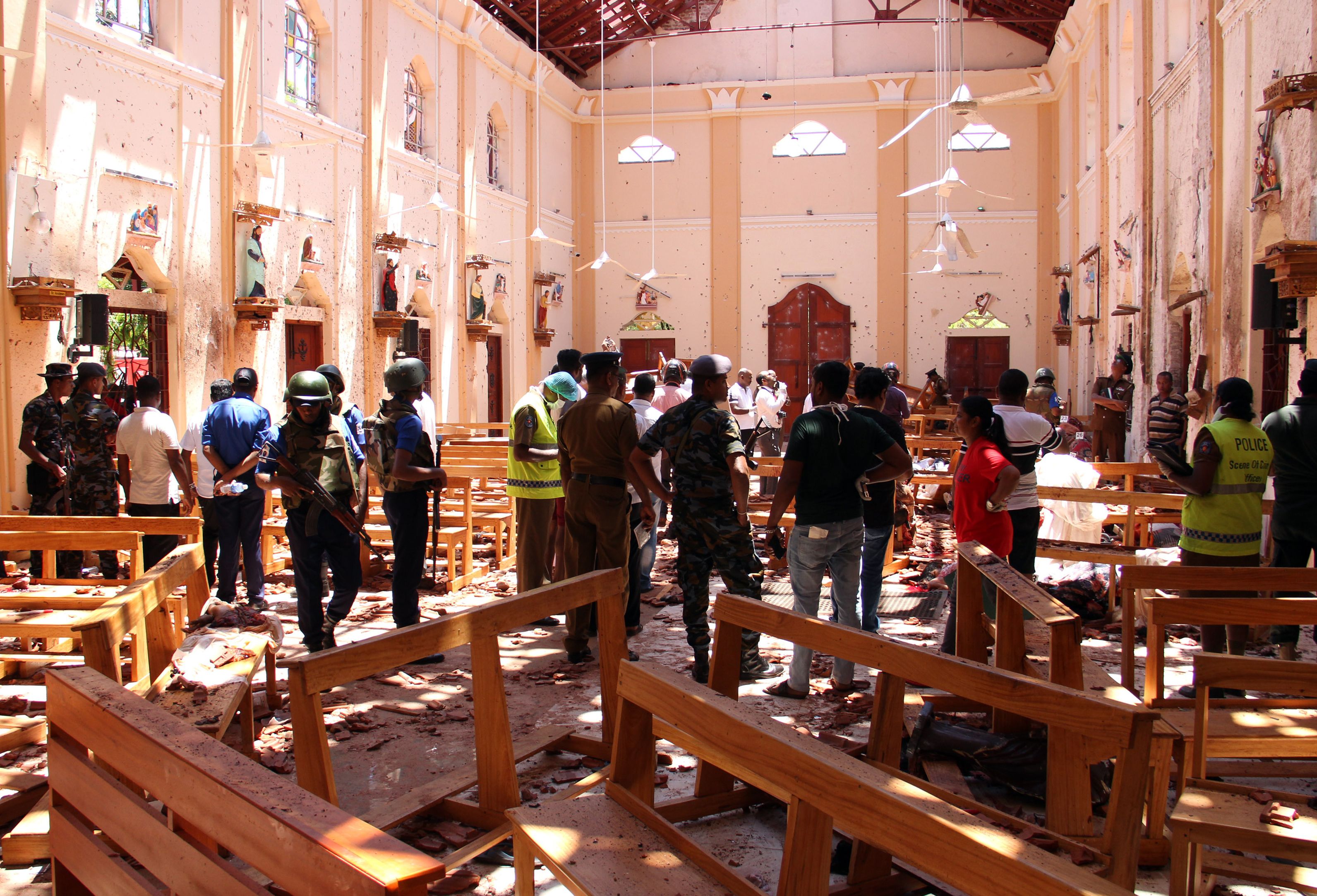 Sri Lankan security personnel walk through debris following an explosion in St. Sebastian's Church in Negombo, north of the capital Colombo, on April 21, 2019. (Credit: STR/AFP/Getty Images)