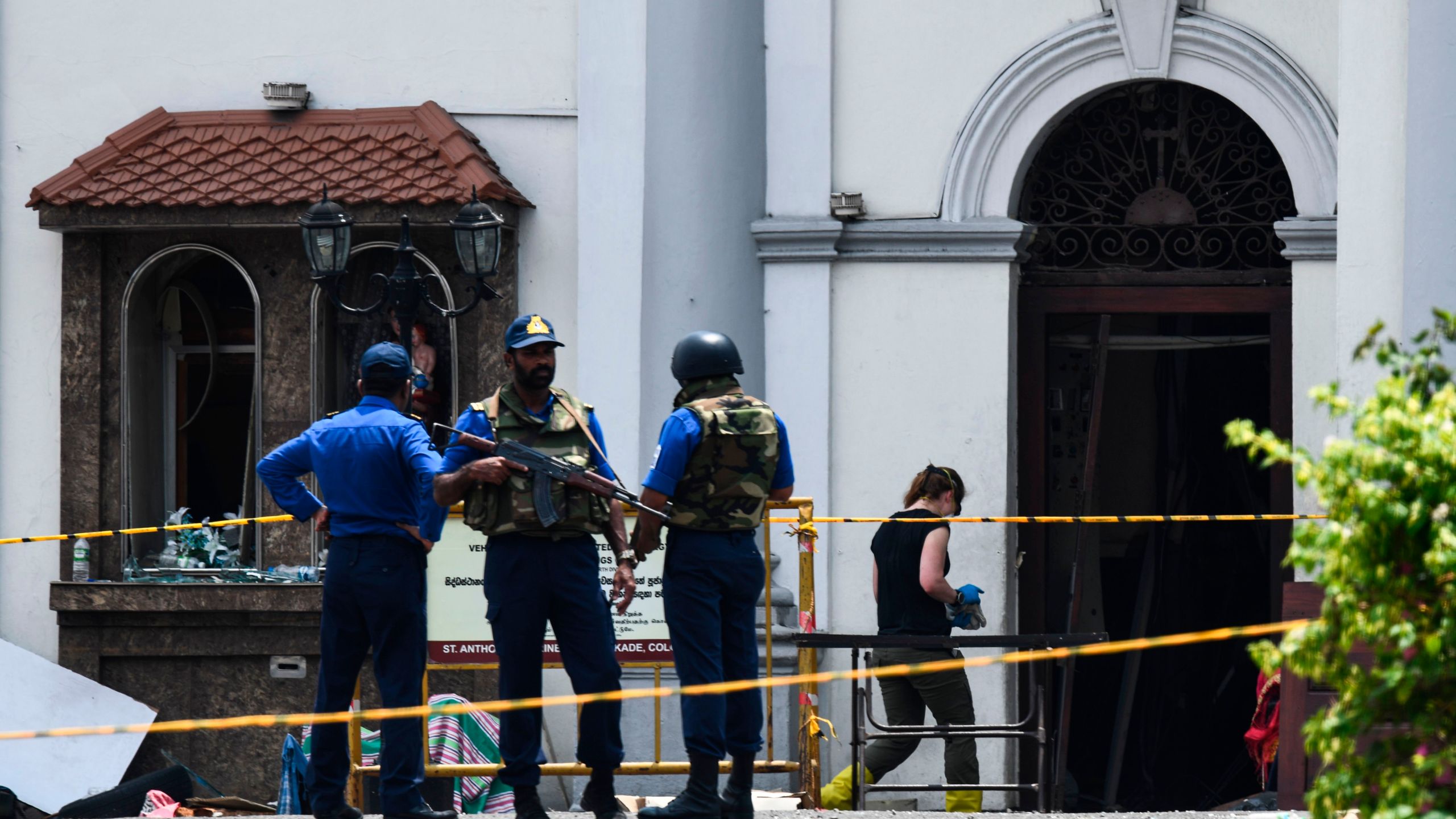 A foreign investigator (R) walks into St. Anthony's Shrine as soldiers stand guard in Colombo on April 25, 2019. (Credit: JEWEL SAMAD/AFP/Getty Images)