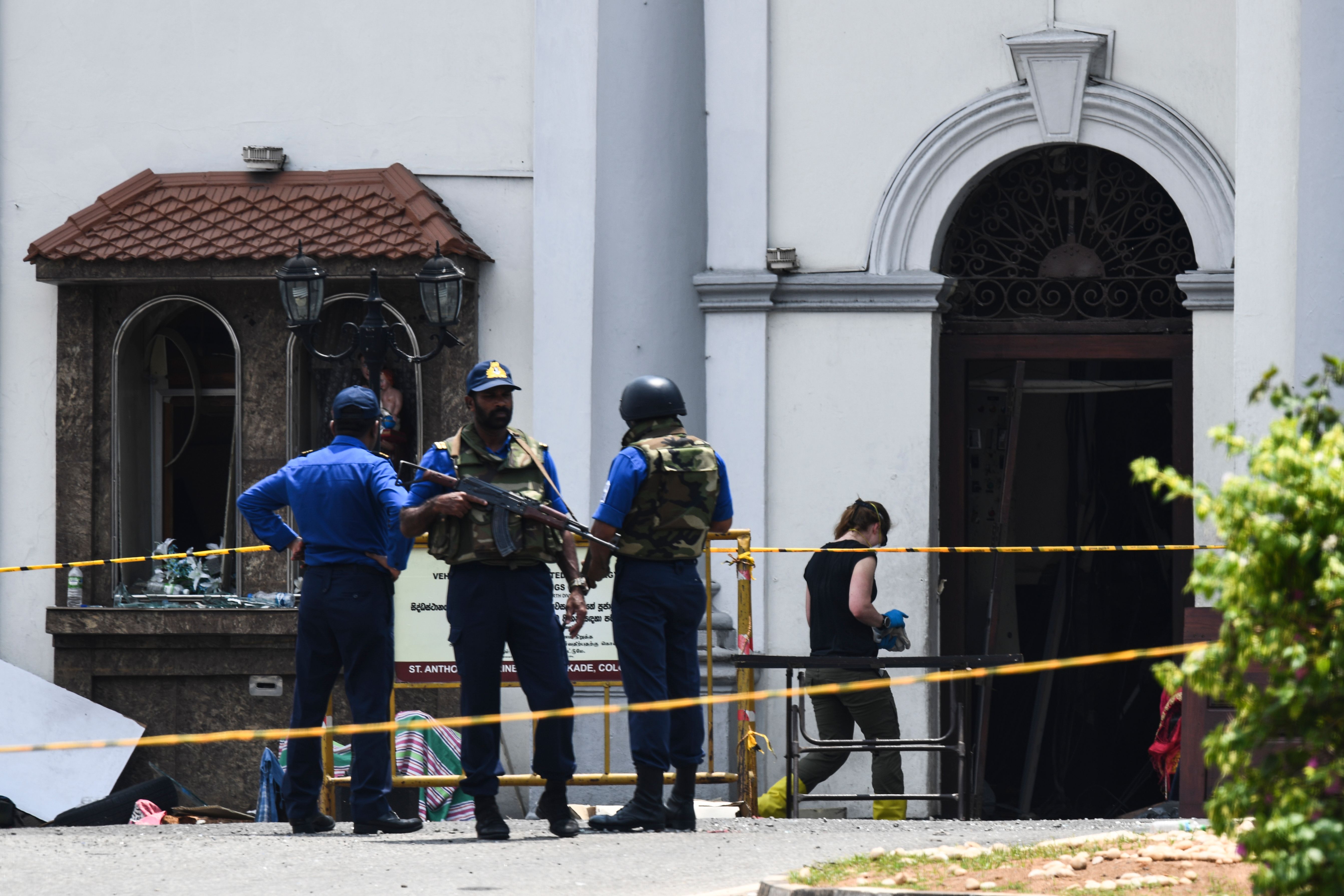 A foreign investigator (R) walks into St. Anthony's Shrine as soldiers stand guard in Colombo on April 25, 2019. (Credit: JEWEL SAMAD/AFP/Getty Images)