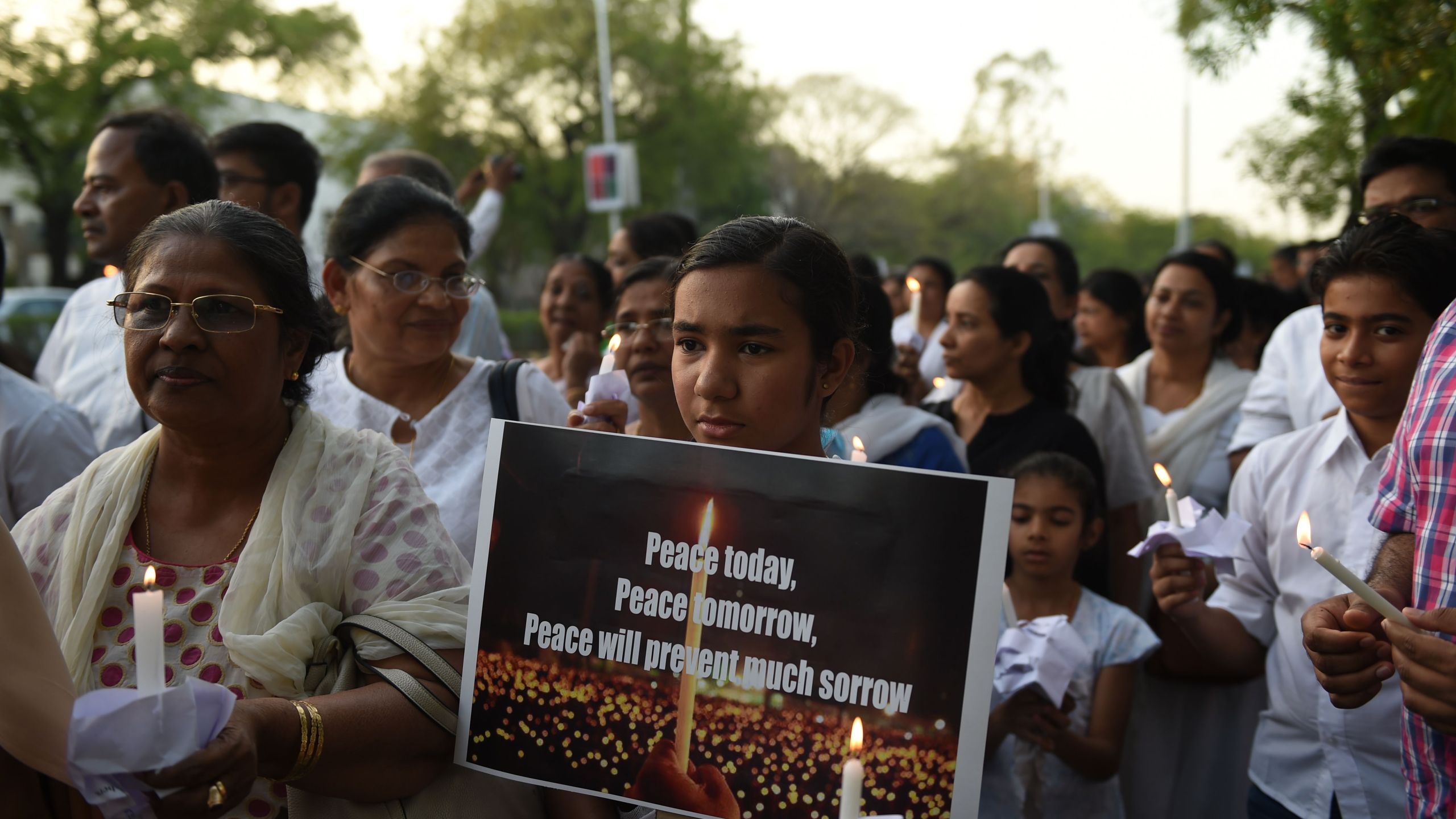 Indian Christians hold placards and candles as they participate in a peace march to show solidarity with the Sri Lankan victims of the last week's serial bombings in Ahmedabad on April 28, 2019. Sri Lanka's churches remained shuttered on April 28, 2019, forcing Christians to say prayers of grief in private over the Easter suicide attacks that the country's Roman Catholic leader called "an insult to humanity". (Credit: SAM PANTHAKY/AFP/Getty Images)