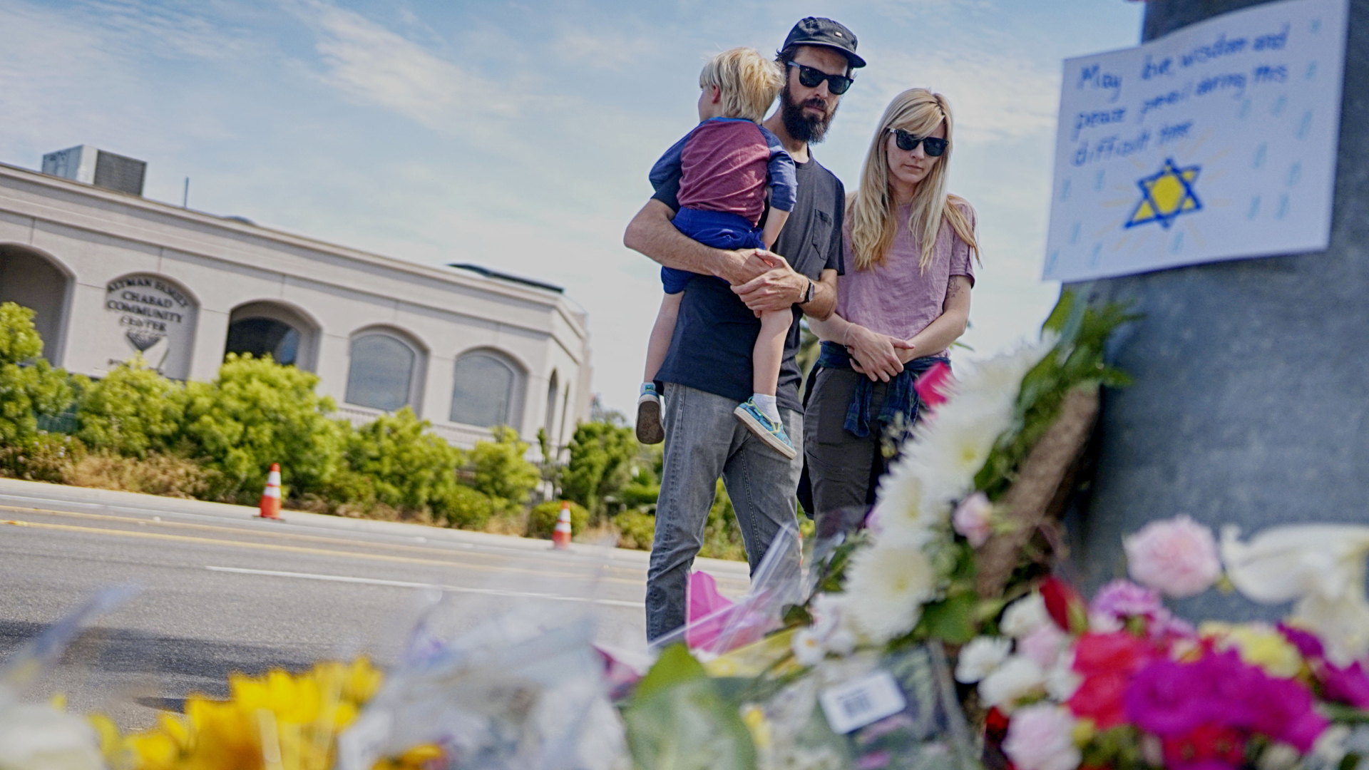 Mourners look over a make-shift memorial across the street from the Chabad of Poway Synagogue on April 28, 2019, in Poway, California.(Credit: Sandy Huffaker/AFP/Getty Images)