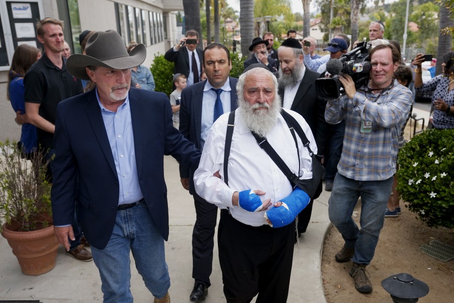 Executive Director Rabbi Ysrael Goldstein, who was shot in the hands, walks towards a press conference with Poway Mayor Steve Vaus outside of the Chabad of Poway Synagogue on April 28, 2019, in Poway, Calif. (Credit: SANDY HUFFAKER/AFP/Getty Images)