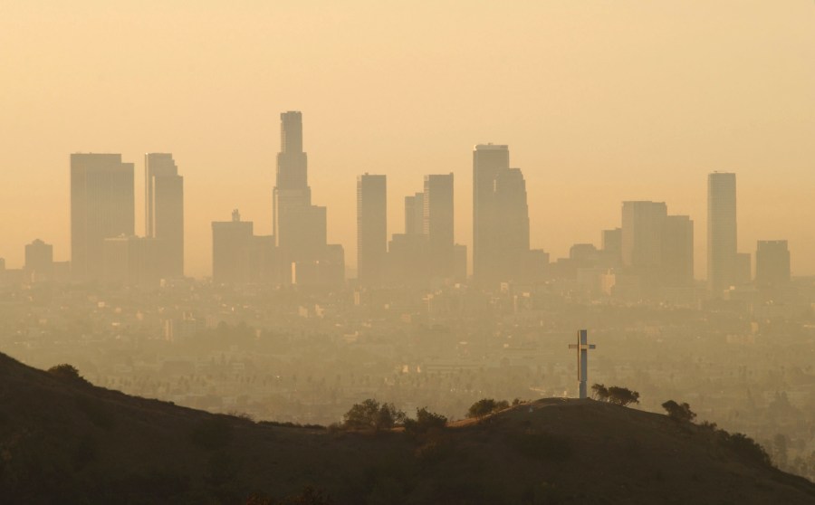 Downtown highrise buildings are shown cloaked in dirty air shortly after sunrise September 11, 2002 in Los Angeles. (Credit: David McNew/Getty Images)